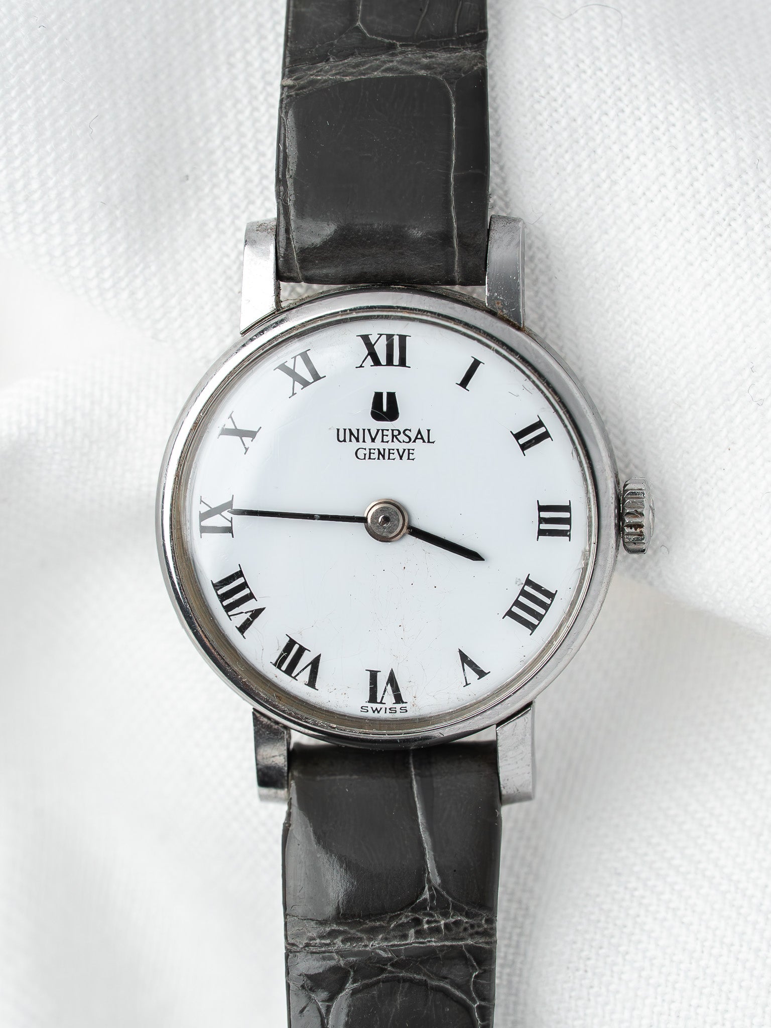 Universal Geneve vintage watch with white dial, Roman numerals, black leather strap