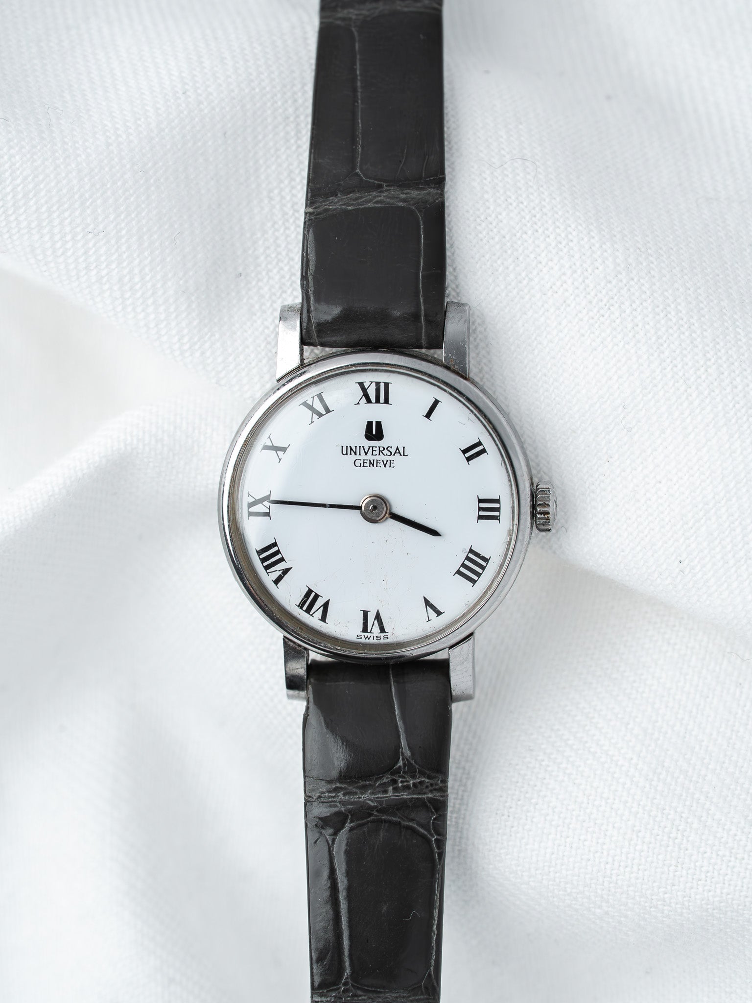 Universal Geneve vintage watch with white dial, Roman numerals, black leather strap