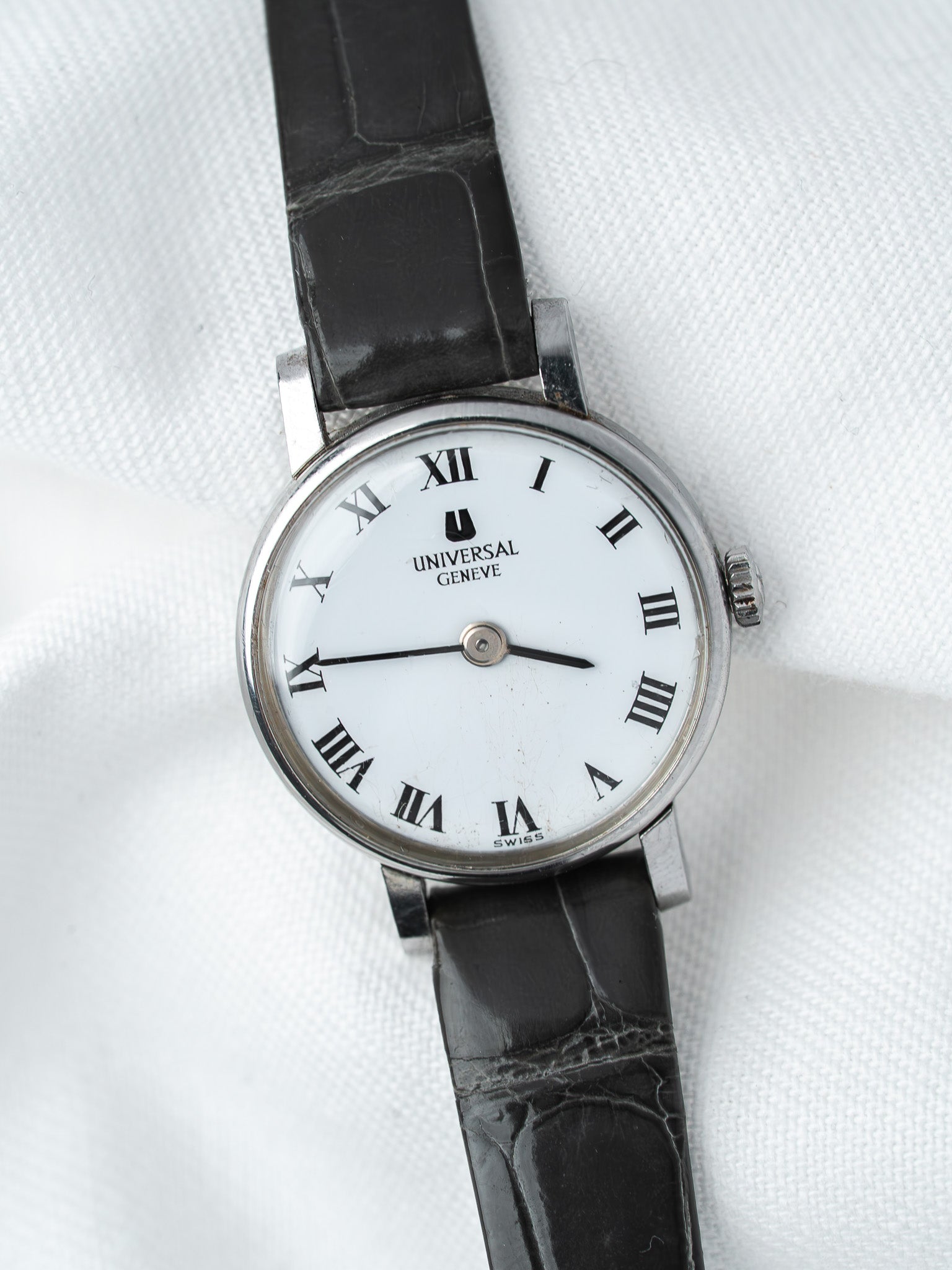 Universal Geneve vintage watch with white dial, Roman numerals, black leather strap