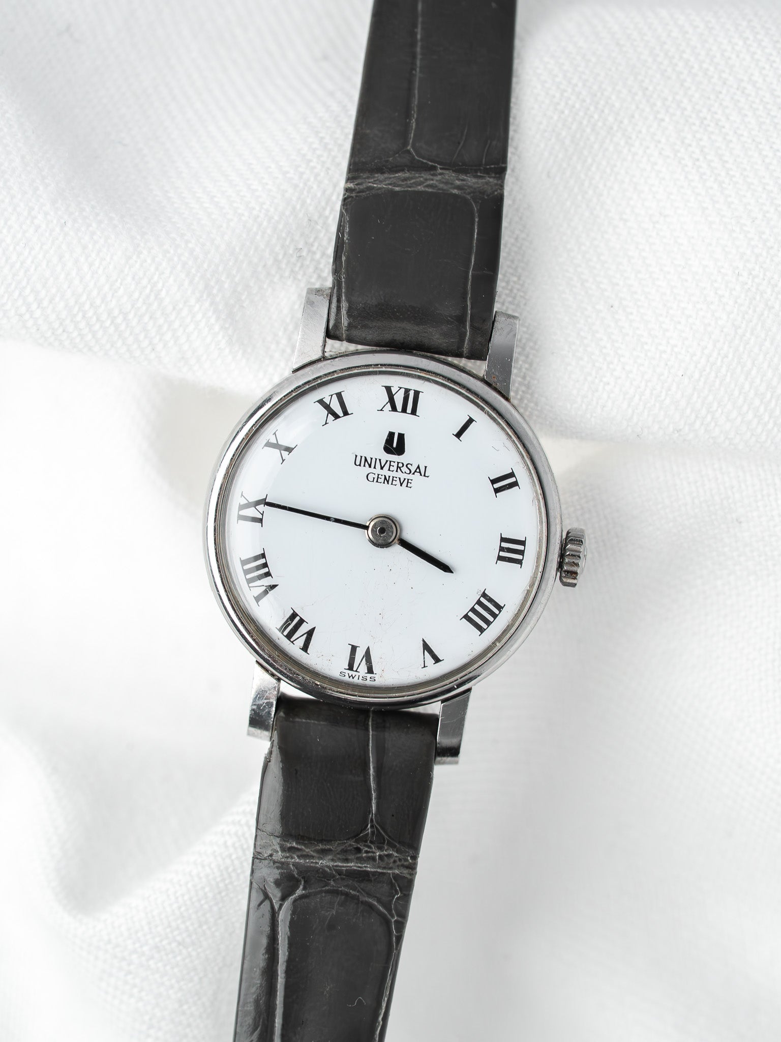 Universal Geneve vintage watch with white dial, Roman numerals, black leather strap