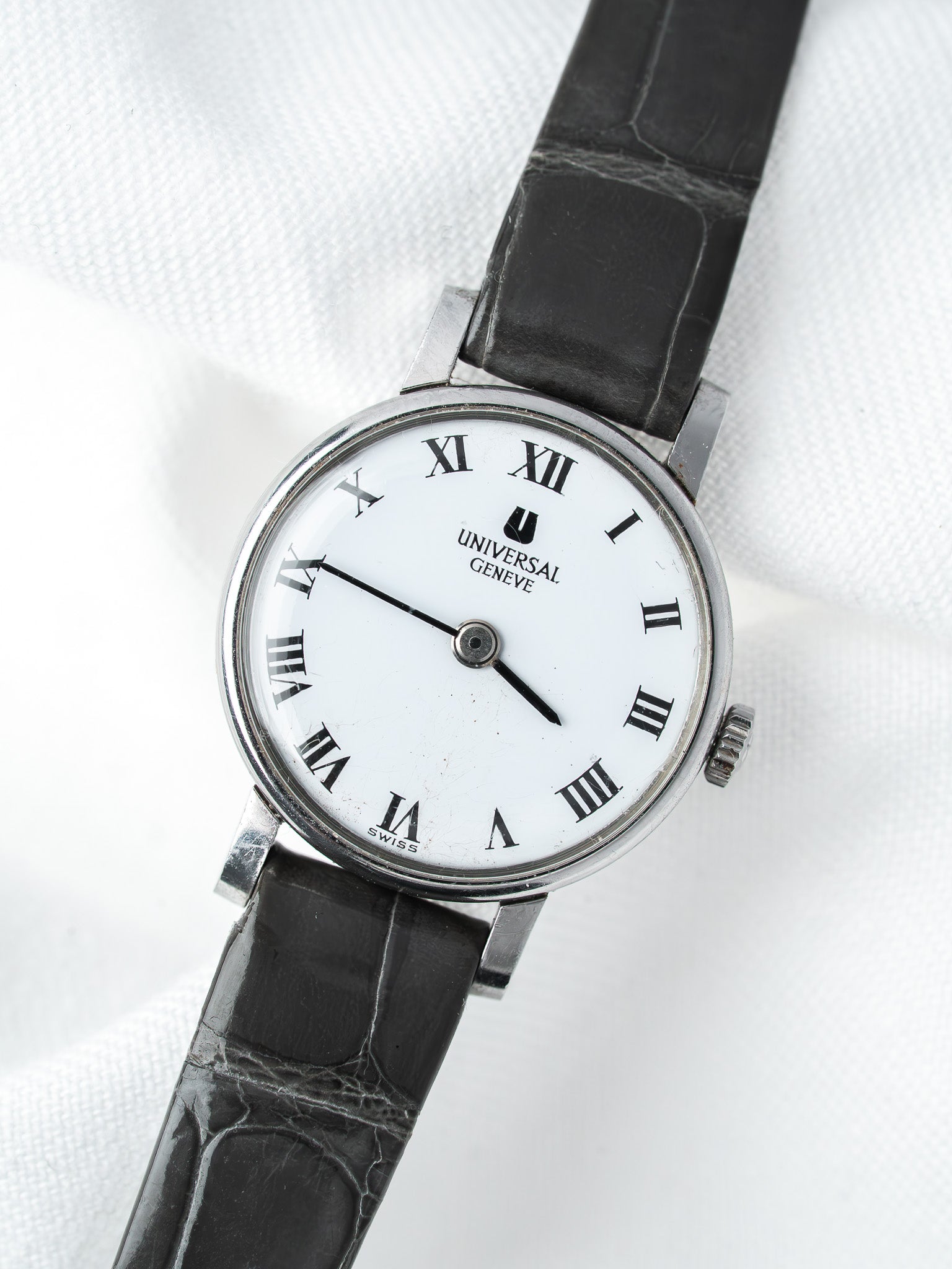 Universal Geneve vintage watch with white dial, Roman numerals, black leather strap