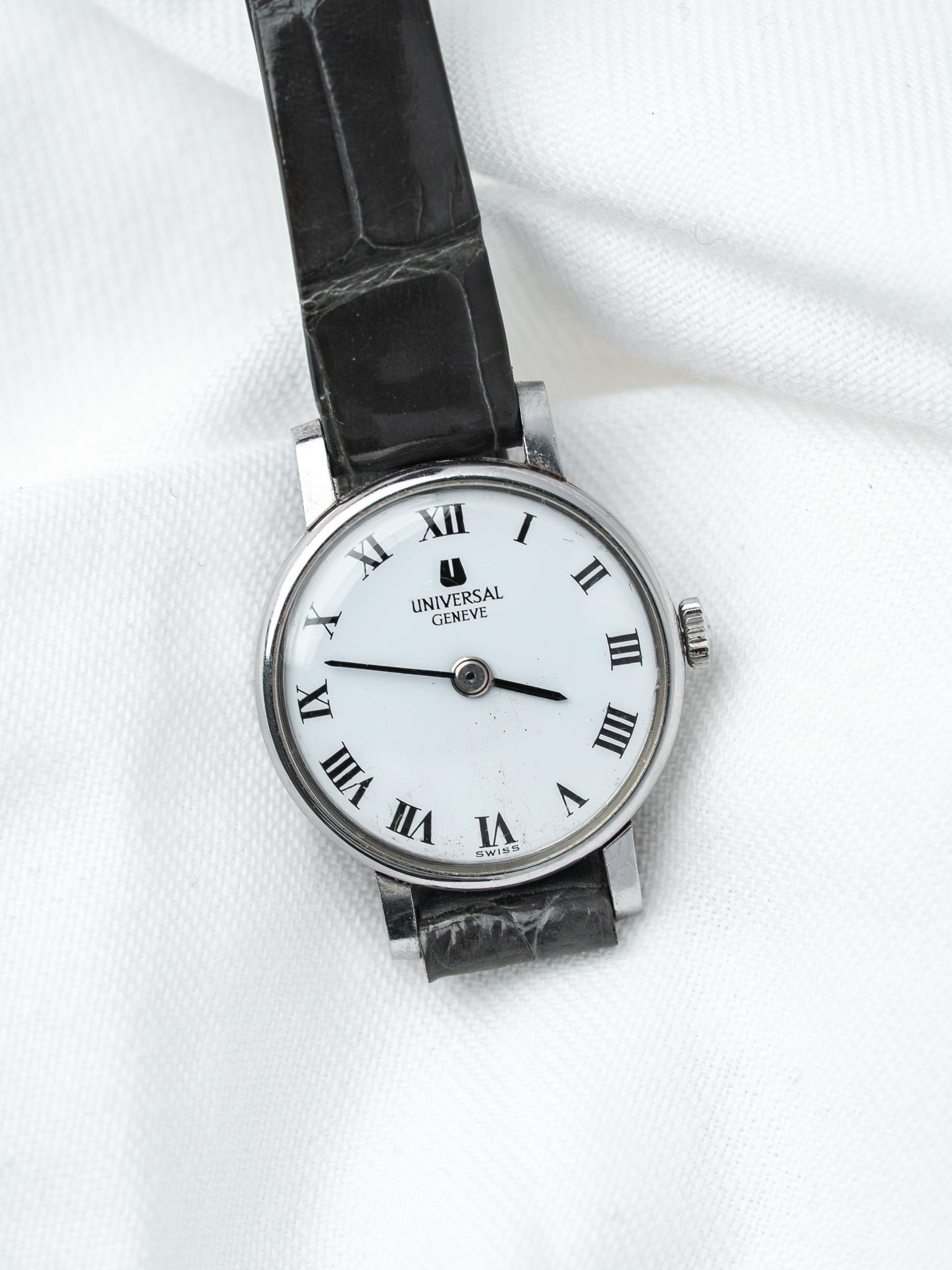 Universal Geneve vintage watch with white dial, Roman numerals, black leather strap