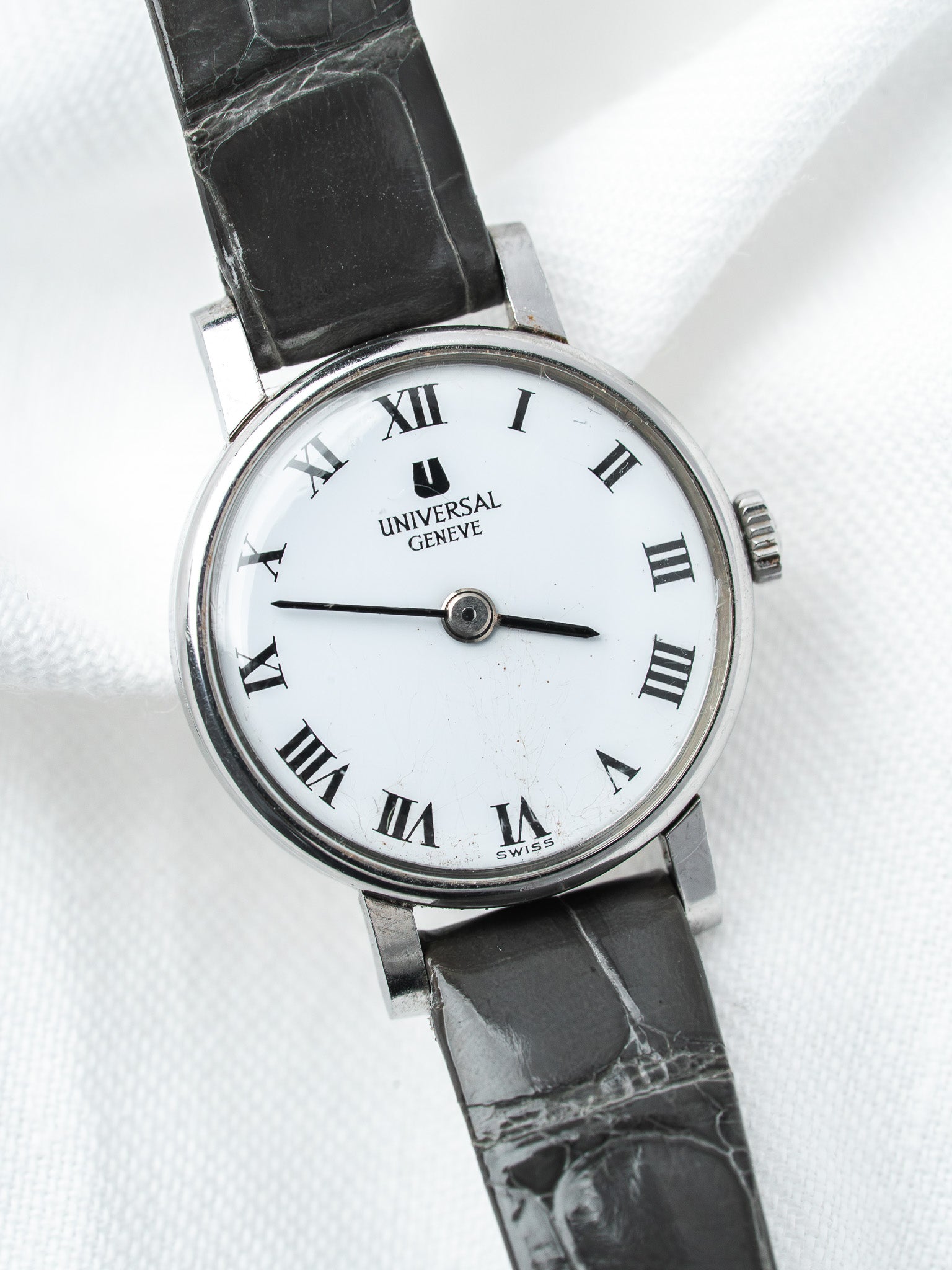 Universal Geneve vintage watch with white dial, Roman numerals, black leather strap