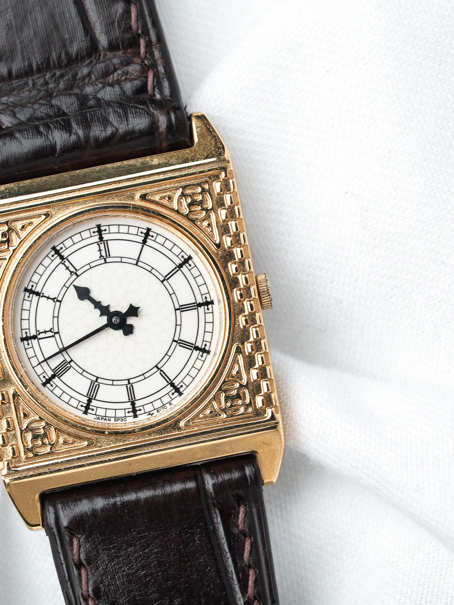 Vintage Seiko watch with gold case, white dial, Roman numerals, brown leather strap