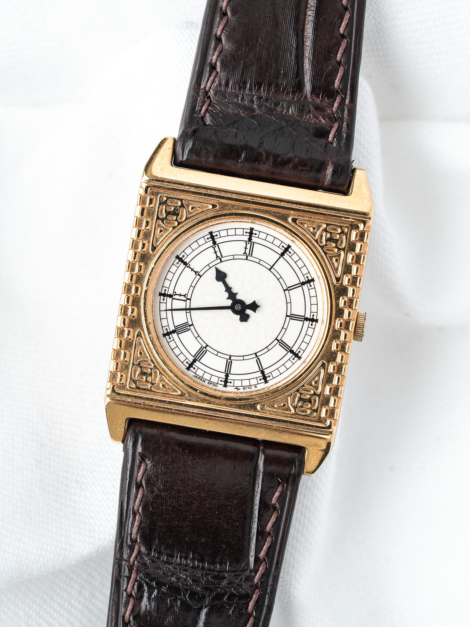 Vintage Seiko watch with gold case, white dial, Roman numerals, brown leather strap