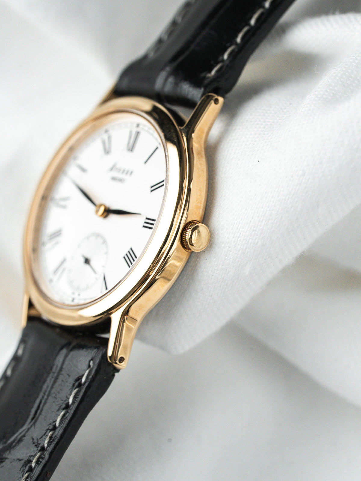 Montre Longines vintage, boîtier or, cadran blanc et bracelet en cuir noir