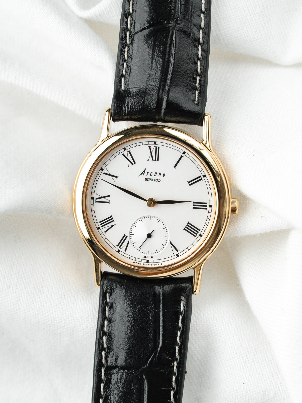 Montre Seiko Avenue vintage, boîtier doré, cadran blanc et bracelet en cuir noir