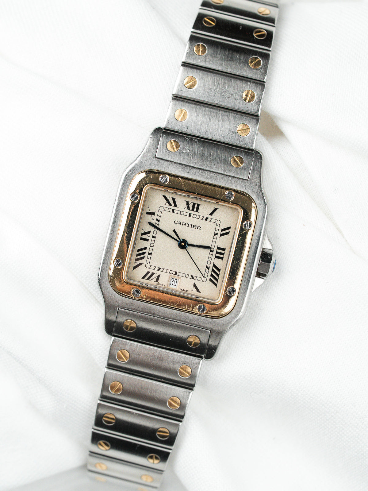 Montre Cartier vintage en acier et or, boîtier rectangulaire, cadran blanc, fond blanc
