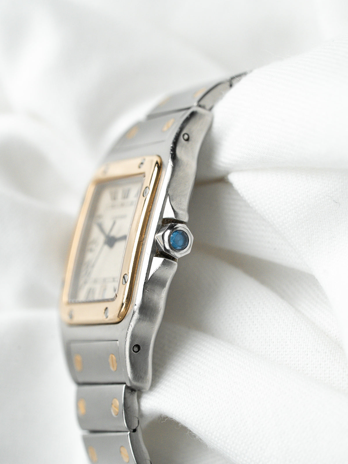 Montre Cartier Santos vintage en acier et or, boîtier rectangulaire sur fond blanc