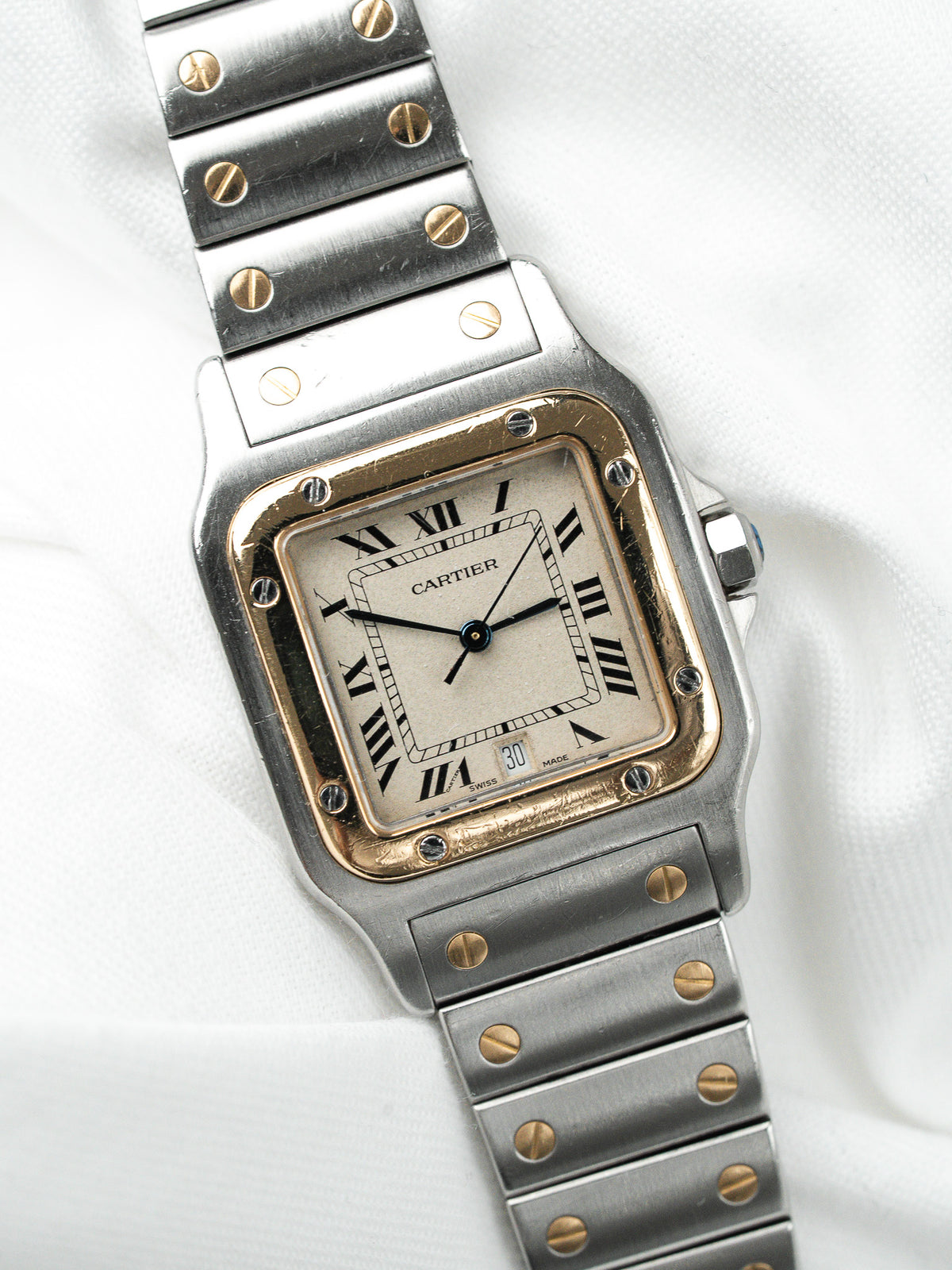 Montre Cartier Santos vintage en acier et or, cadran blanc, sur fond blanc