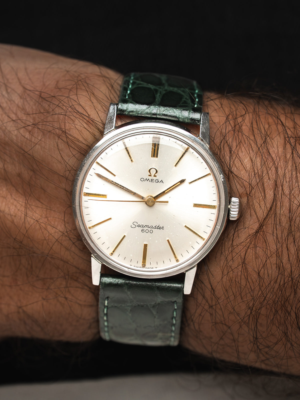 Montre Omega Seamaster 600 vintage, cadran champagne et bracelet cuir vert, portée au poignet