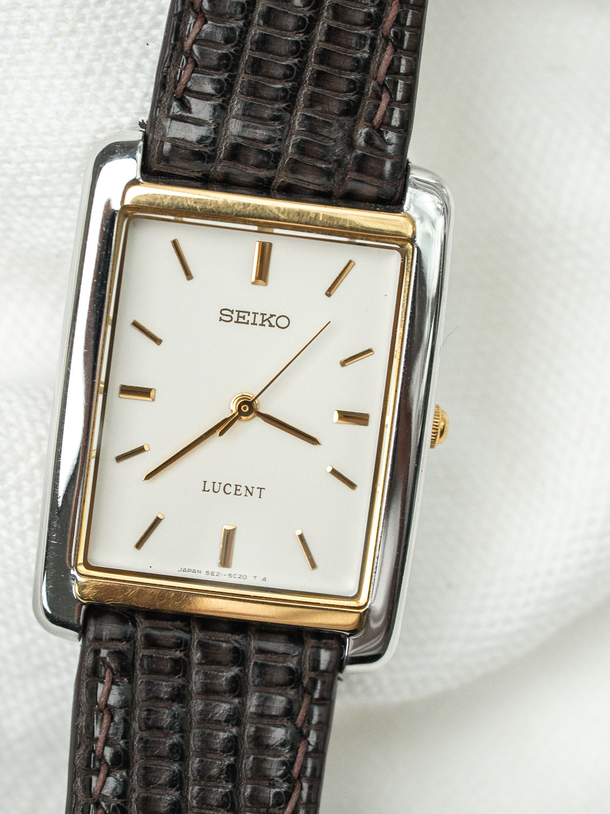 Montre Seiko Lucent vintage au cadran blanc rectangulaire et bracelet en cuir marron.