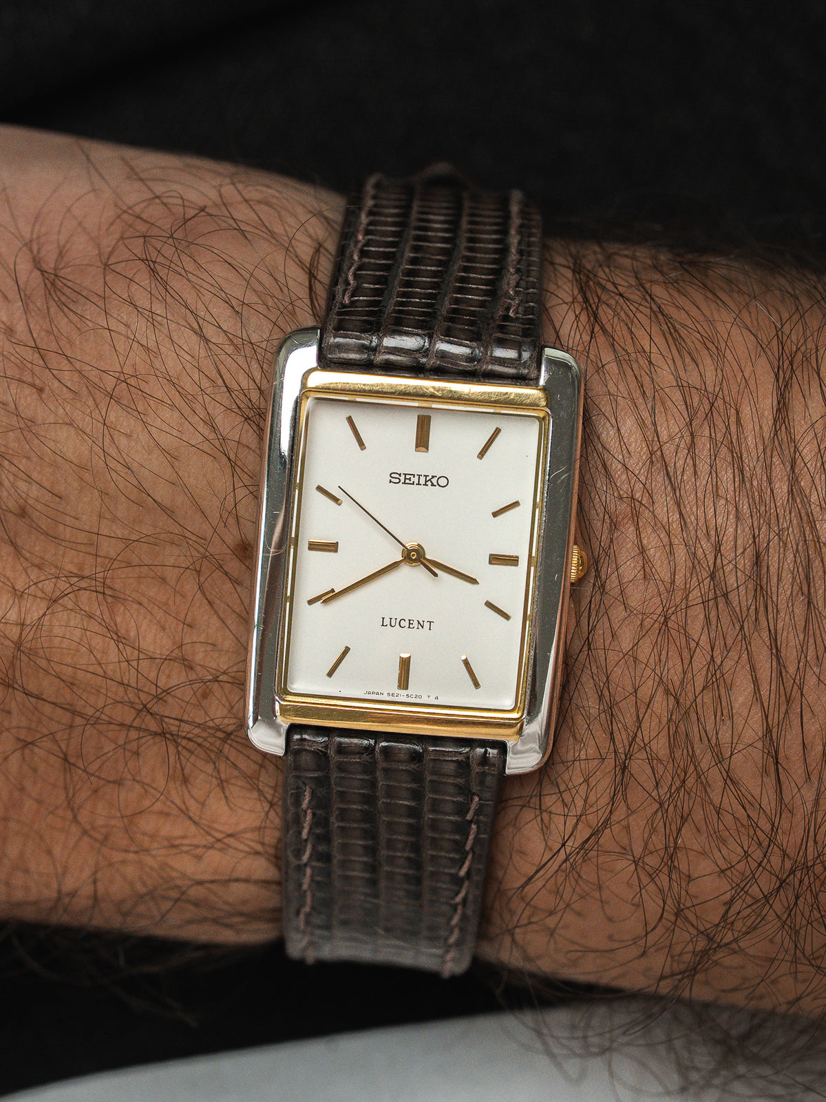 Montre Seiko Lucent vintage rectangulaire avec cadran blanc et bracelet en cuir marron.