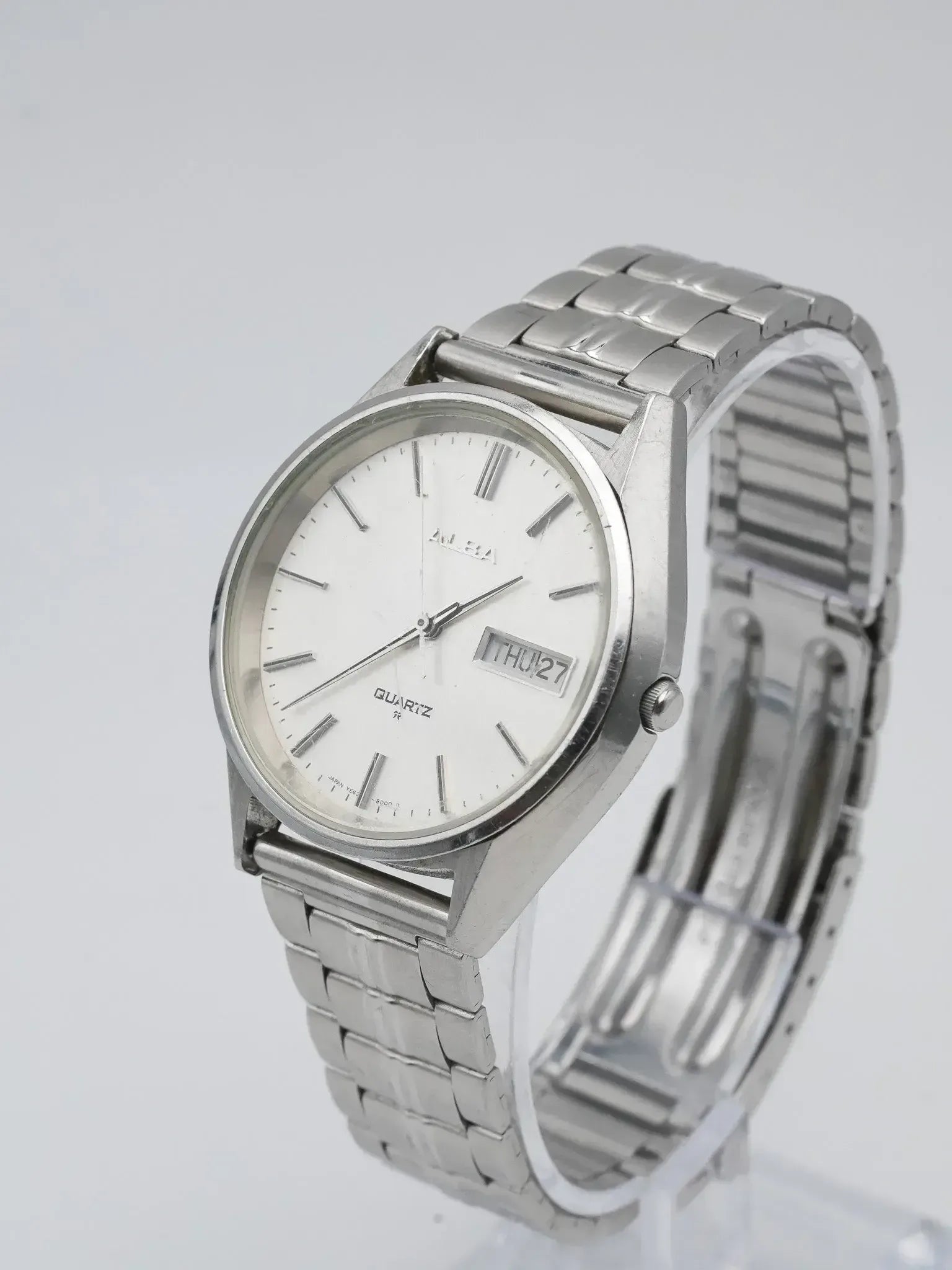 Alba vintage quartz watch with white dial, day-date window, and steel bracelet on display stand