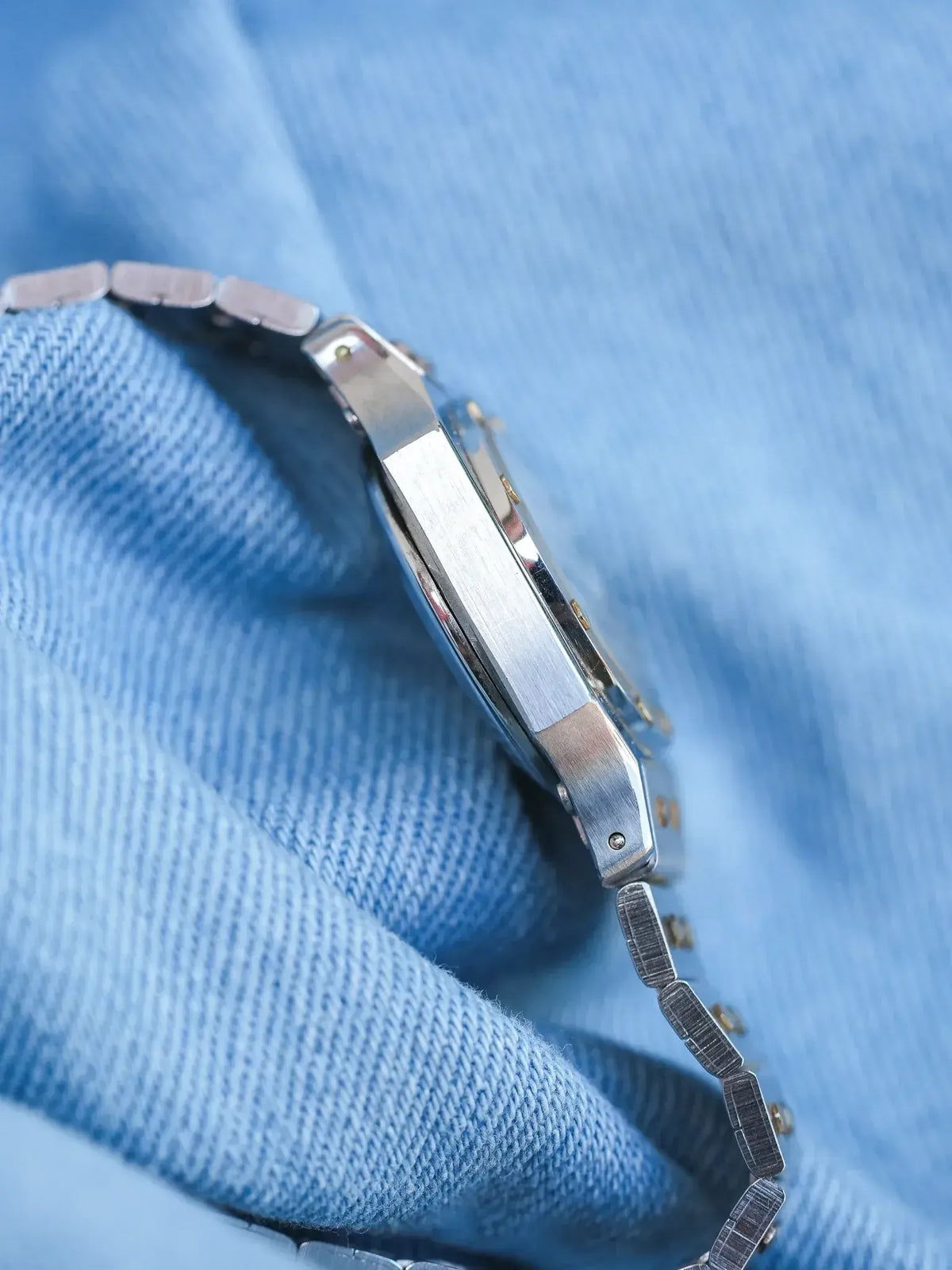 Vintage Omega Constellation watch with steel bracelet on blue fabric background