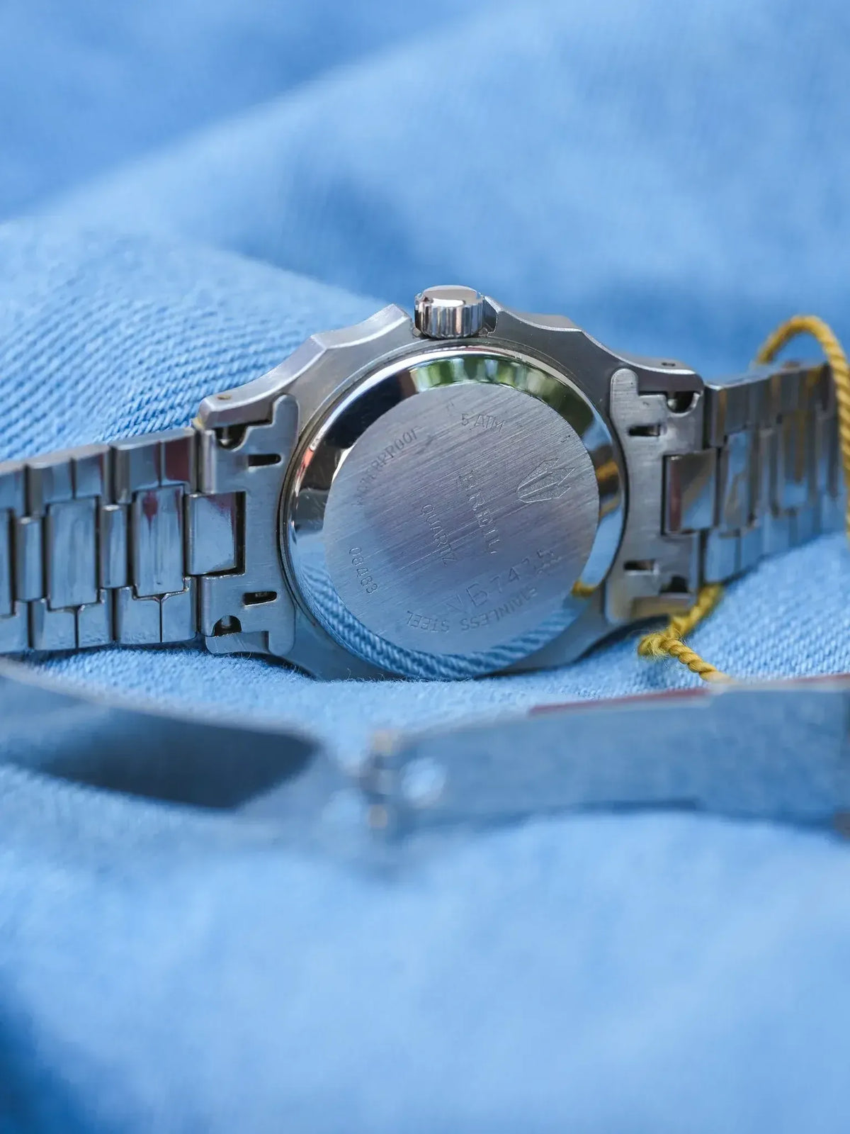 Vintage Seiko watch back, stainless steel case, quartz movement, on blue fabric