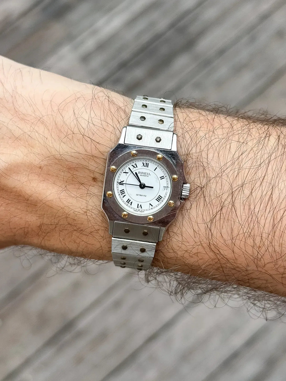Breil vintage watch with white dial, Roman numerals, and steel bracelet worn on wrist