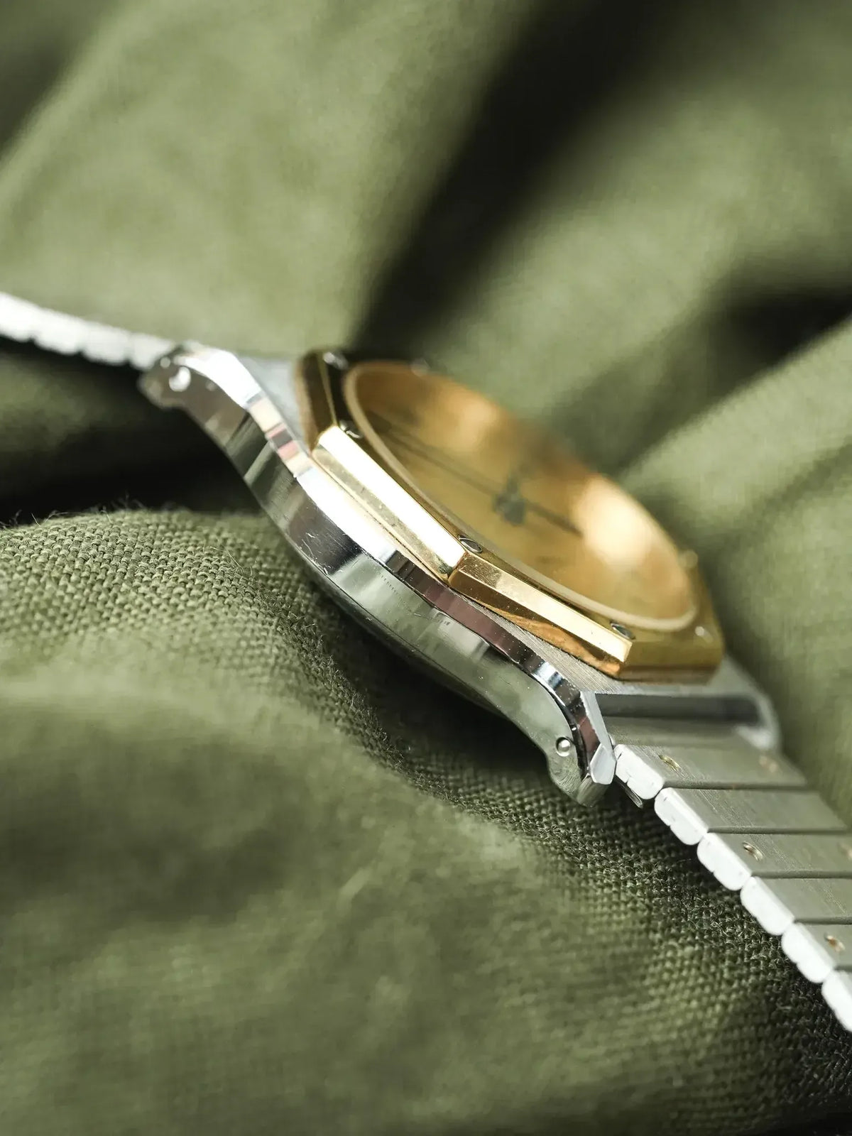 Vintage Omega Constellation watch with gold bezel and steel bracelet on green fabric