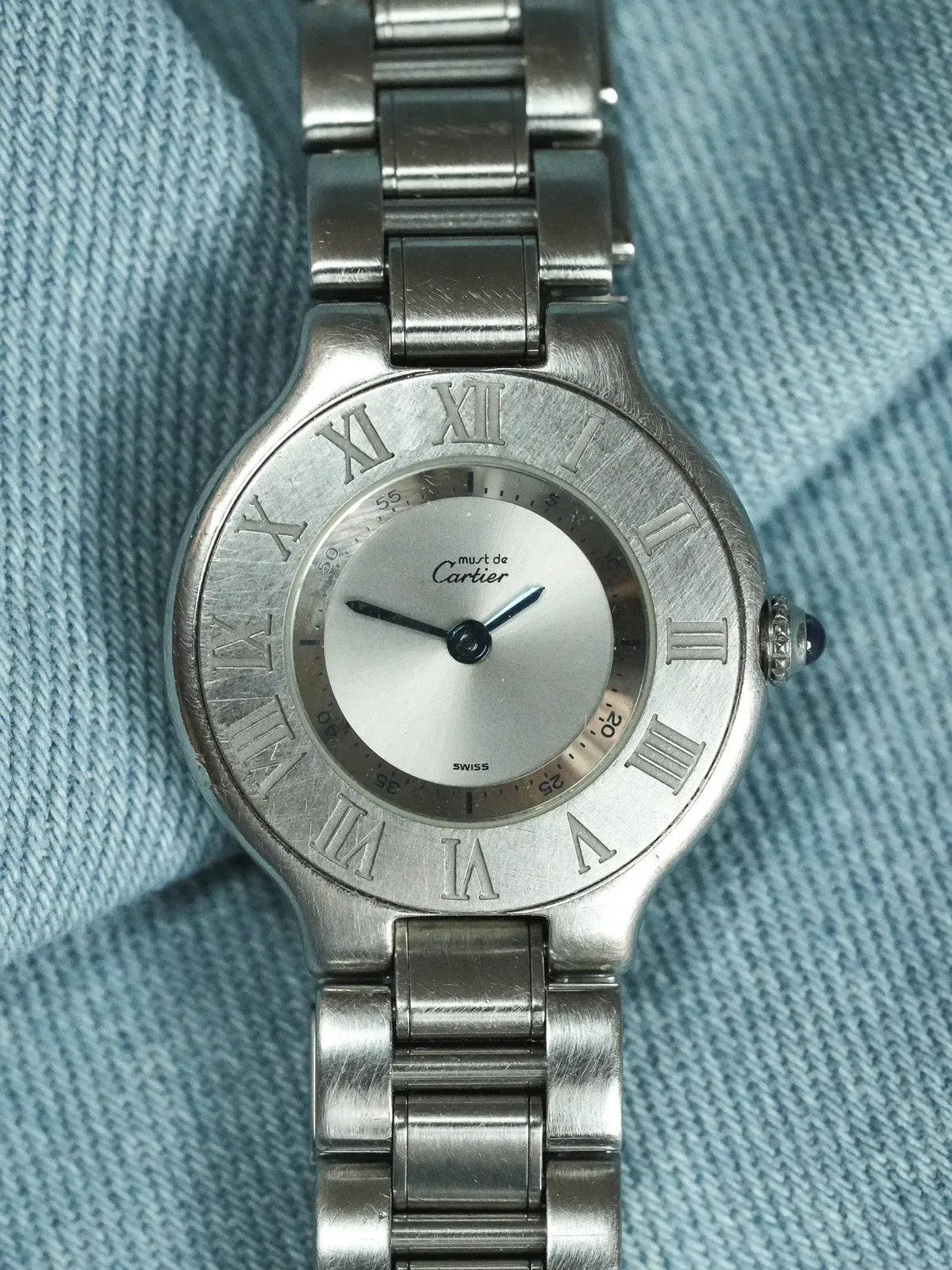 Cartier Must de Cartier vintage watch with silver dial, Roman numerals, steel bracelet on denim