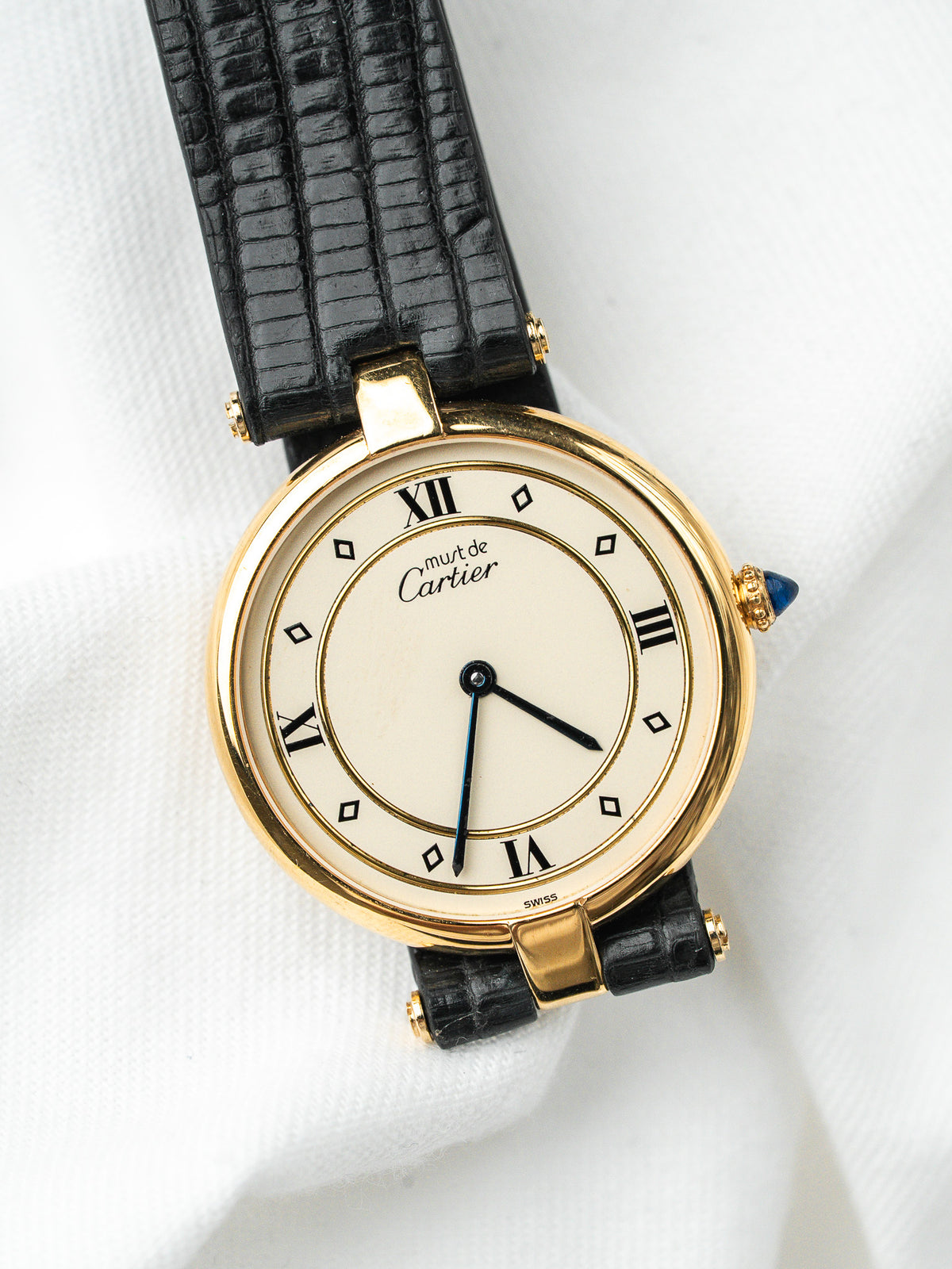 Montre Cartier Must vintage, boîtier rond plaqué or, cadran crème et bracelet cuir noir