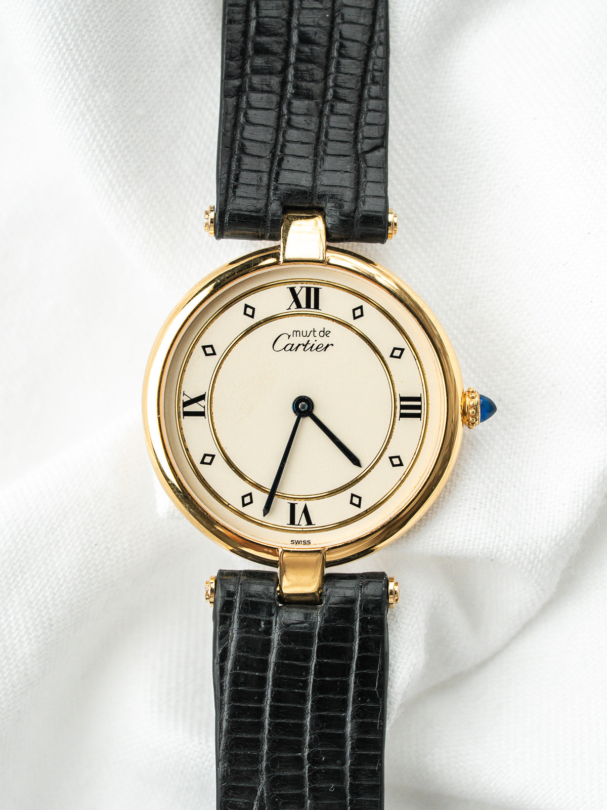 Montre Cartier Must vintage, boîtier rond plaqué or, cadran crème et bracelet cuir noir