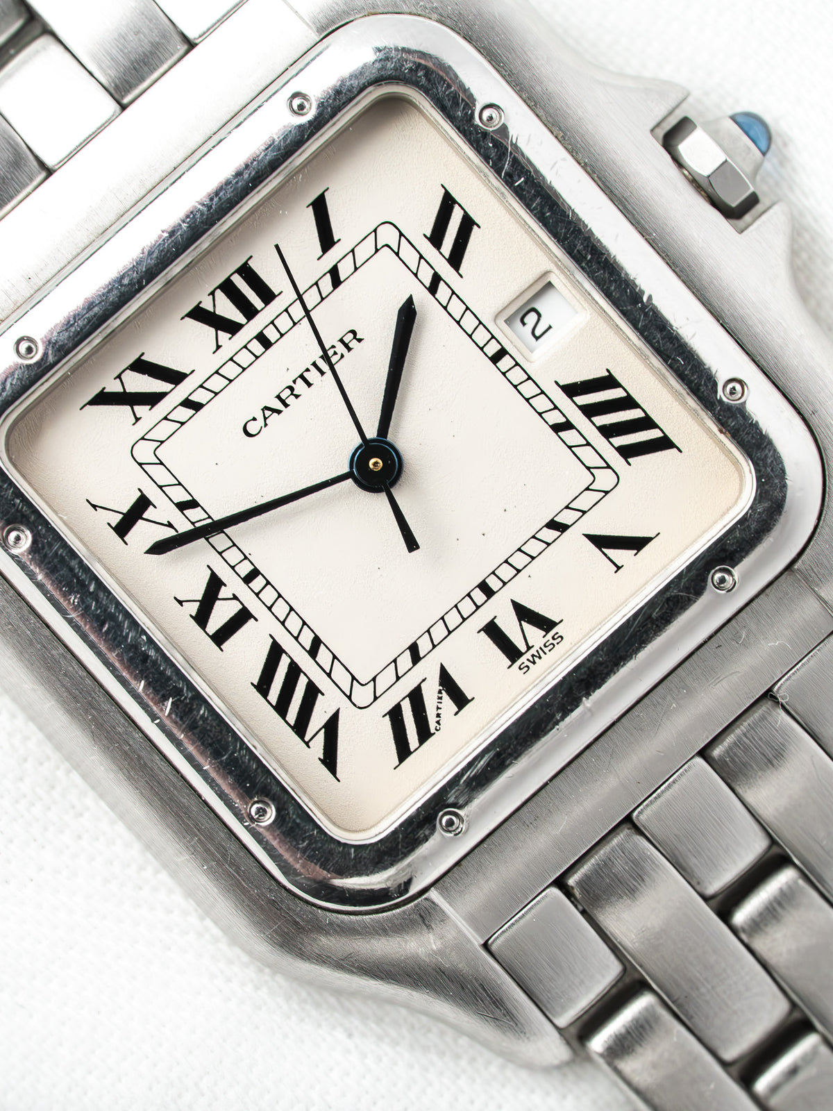 Montre Cartier vintage en acier, boîtier rectangulaire, cadran blanc et bracelet métallique
