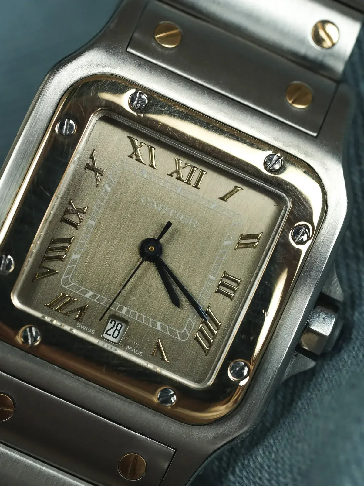 Cartier Santos watch with square steel case, gold accents, and Roman numeral dial