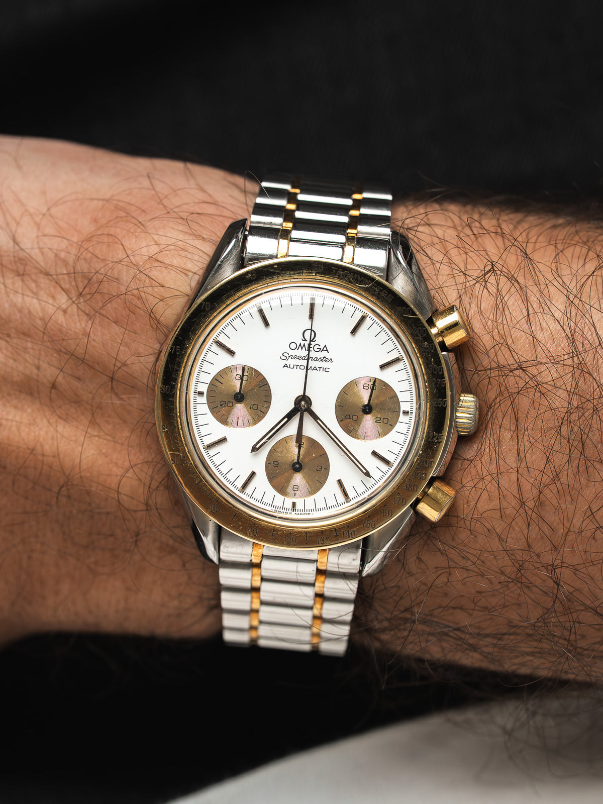 Montre Omega Speedmaster vintage en acier et or, cadran blanc, portée au poignet