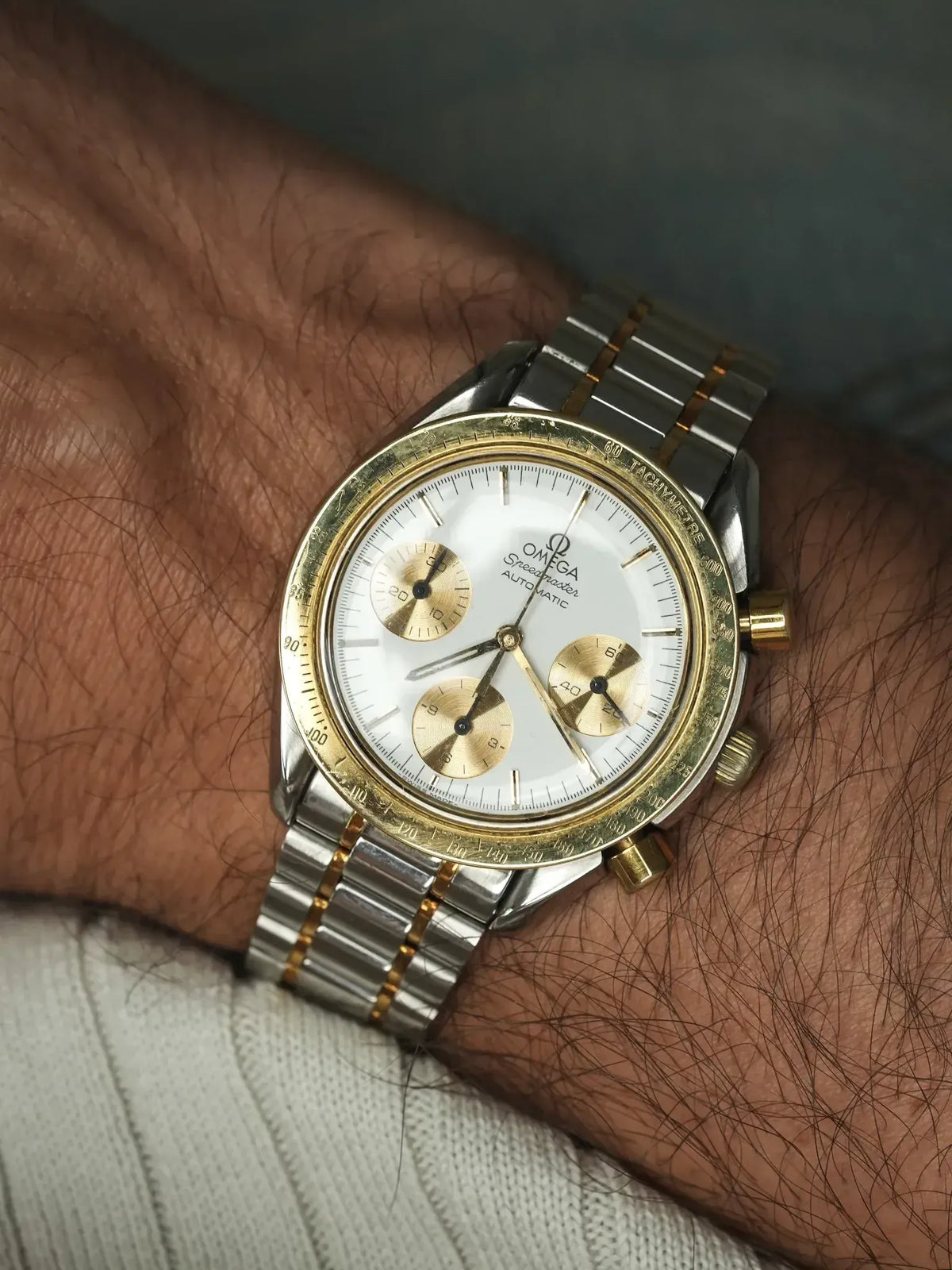 Omega Speedmaster vintage chronograph with white dial, gold subdials, steel and gold bracelet on wrist