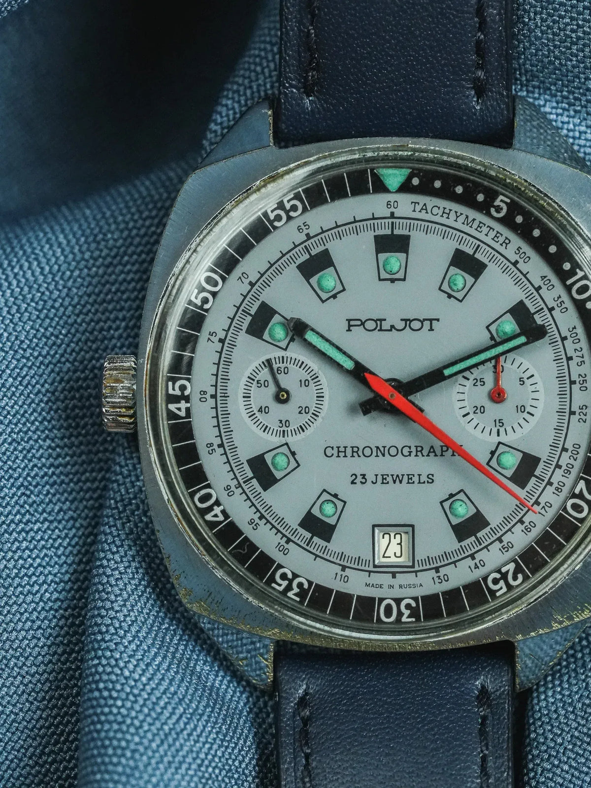 Poljot vintage chronograph watch with grey dial, green markers, and blue leather strap