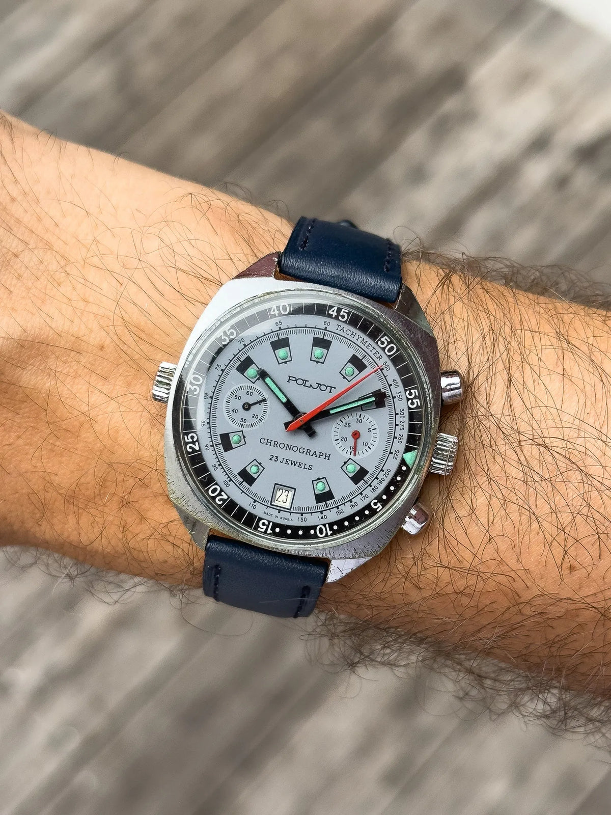 Poljot vintage chronograph watch with silver dial, green markers, blue leather strap on wrist
