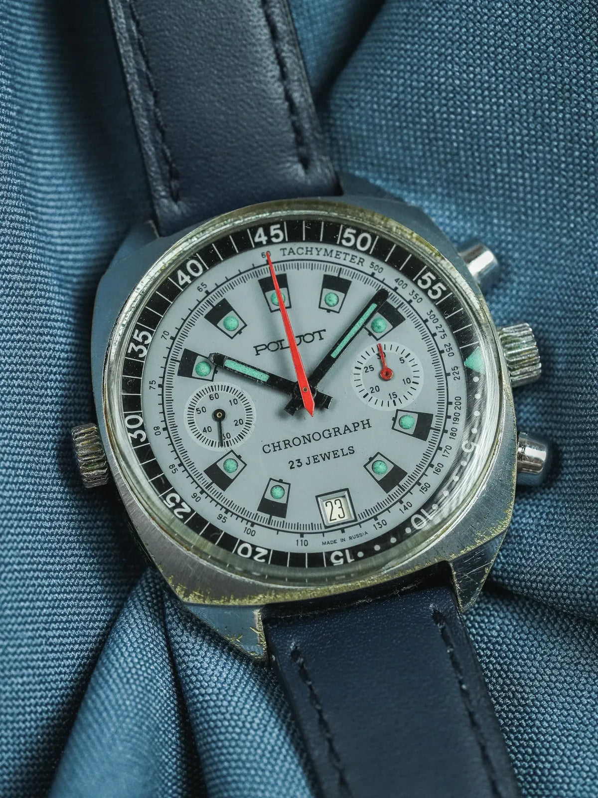 Vintage Poljot chronograph watch with silver dial, black bezel, and blue leather strap