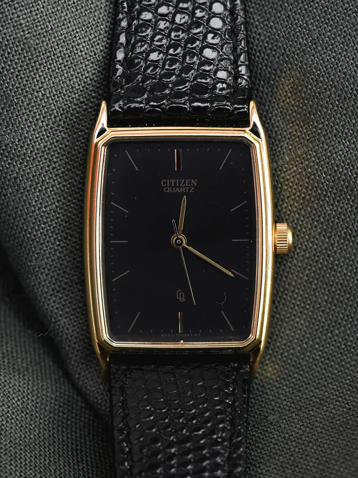 Citizen Quartz vintage watch with gold case, black dial, and textured black strap