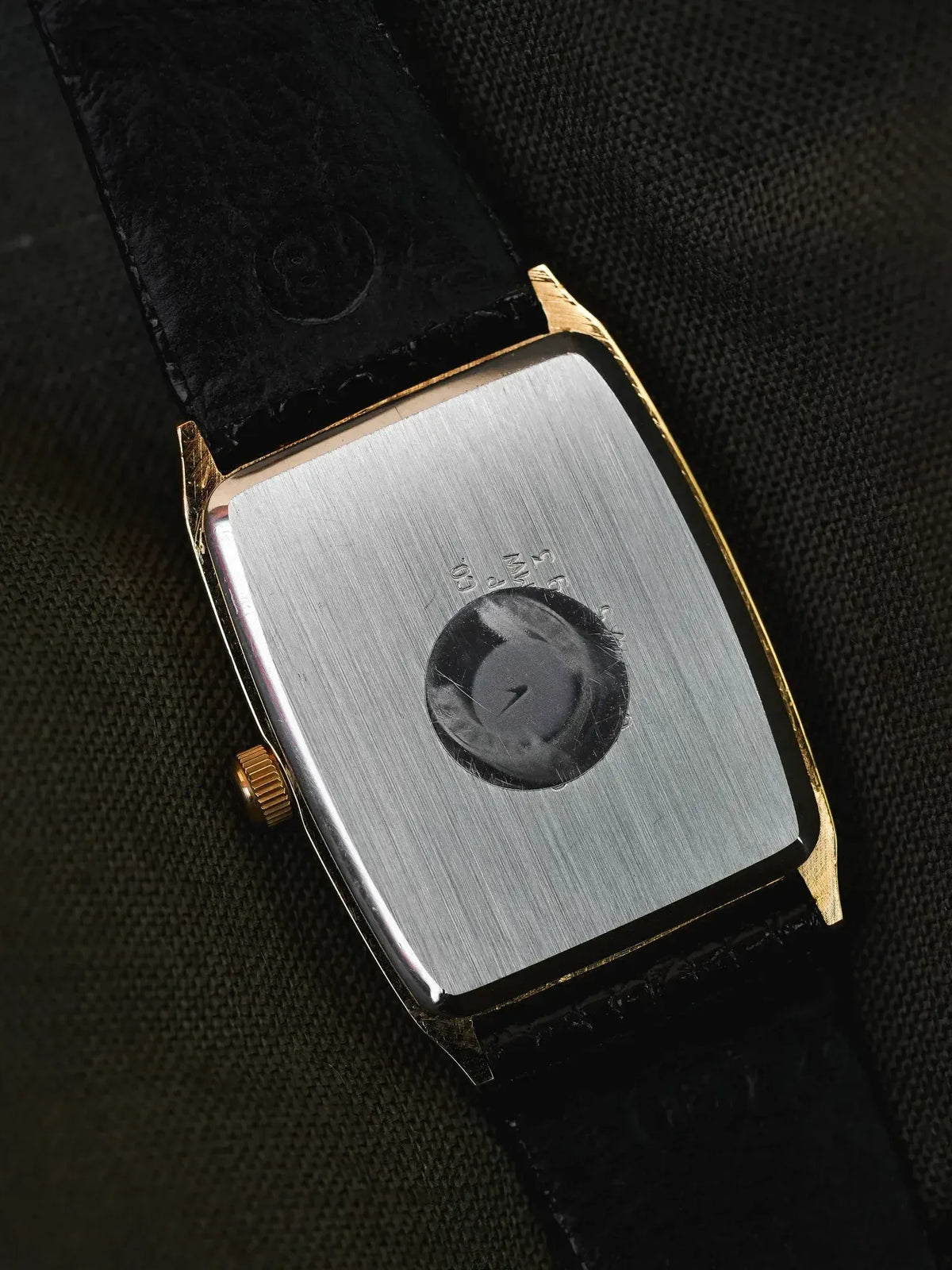Vintage Omega rectangular watch back, brushed steel case, gold accents, black leather strap