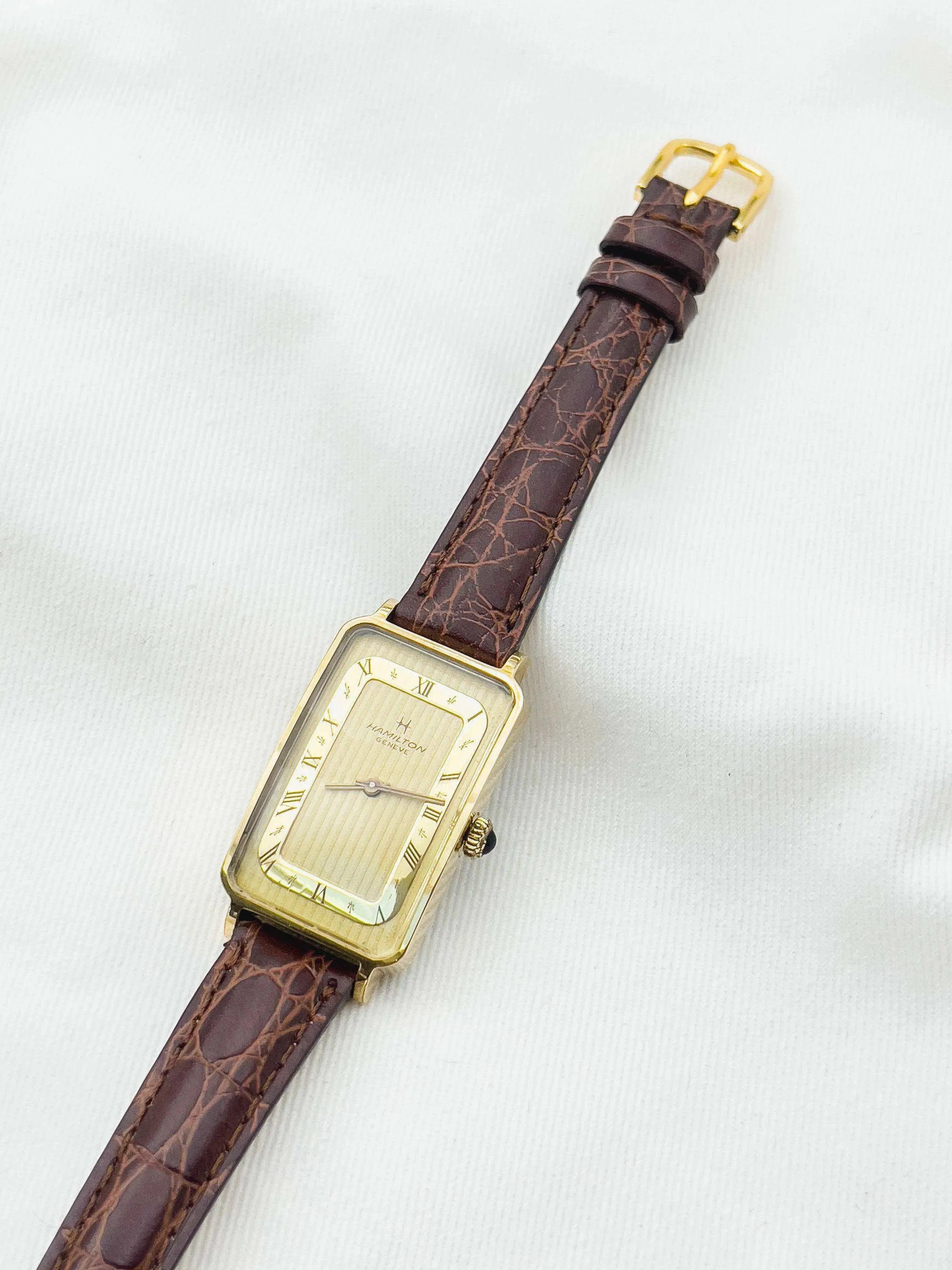Hamilton Geneve vintage watch with gold case, cream dial, Roman numerals, brown alligator strap