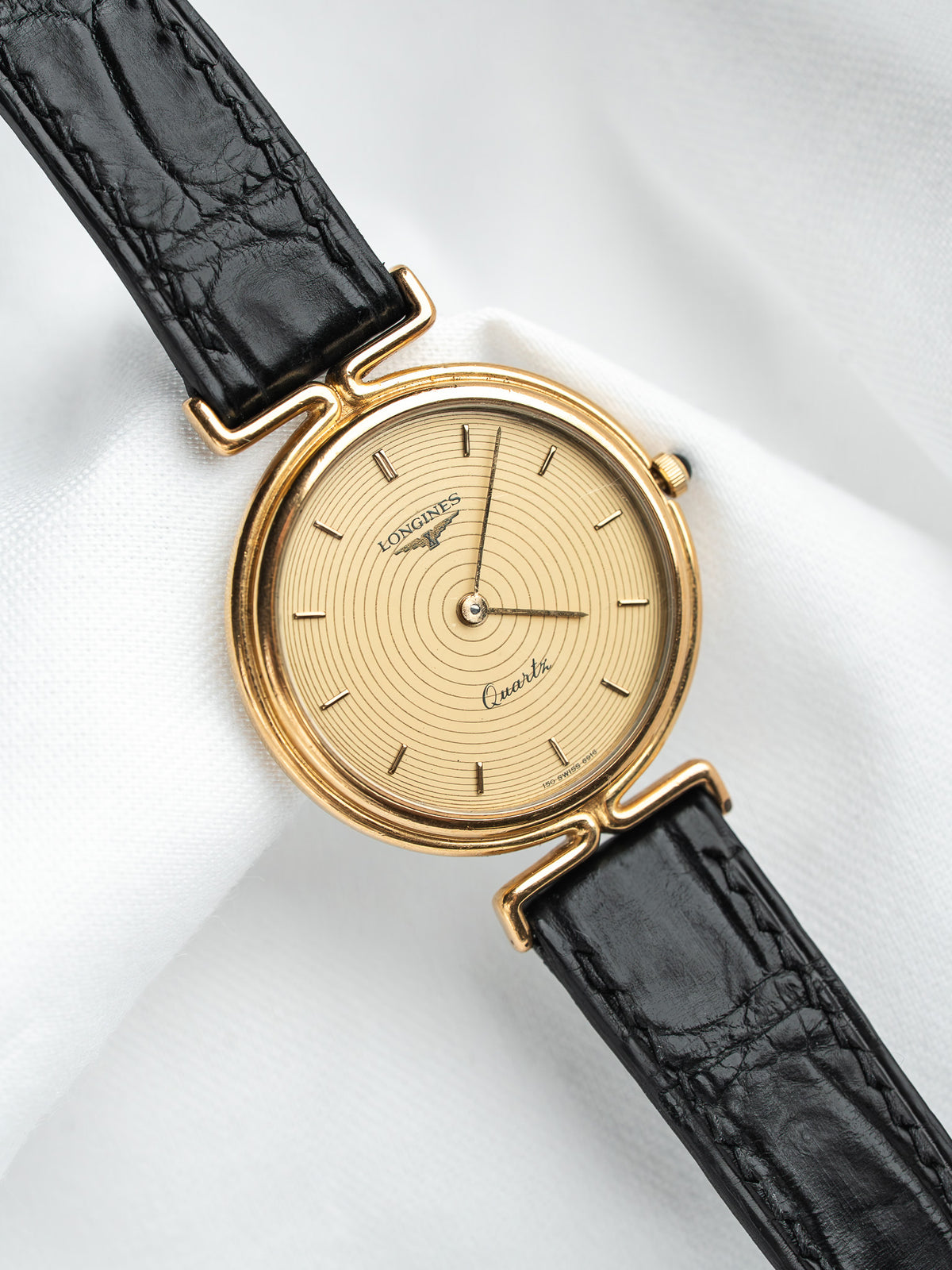 Longines vintage quartz watch with gold case, cream dial, black leather strap