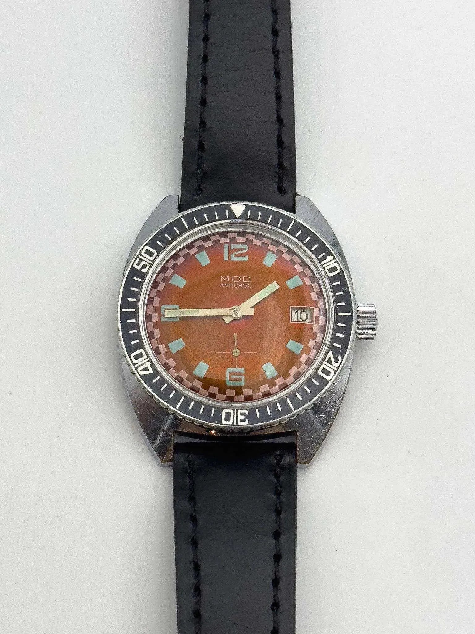 MOD Antichoc vintage watch with orange dial, black bezel, and leather strap