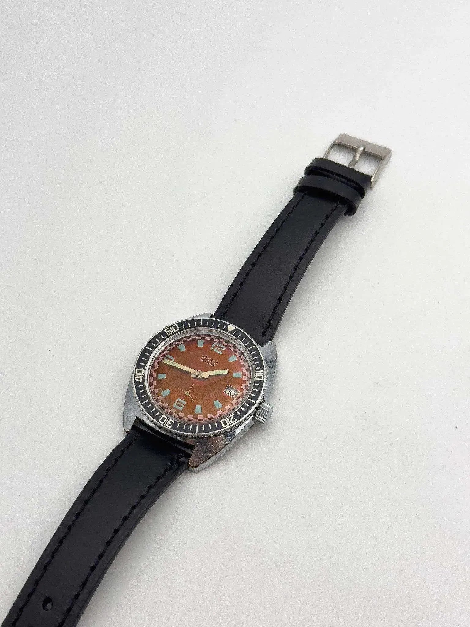 Vintage Mido Multifort watch with orange dial, black leather strap, steel case on white background