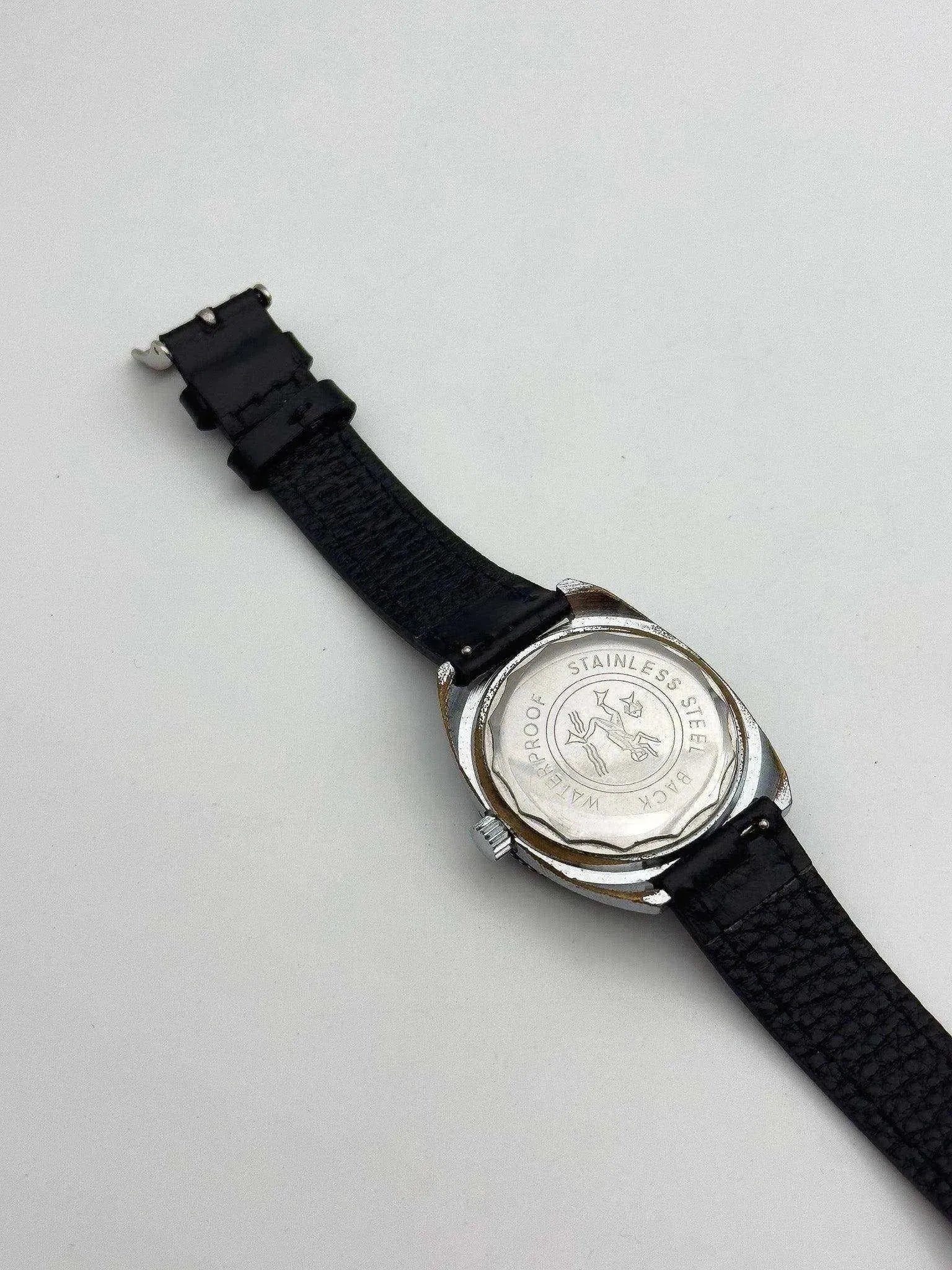 Vintage Omega watch with stainless steel case back and black leather strap on white background