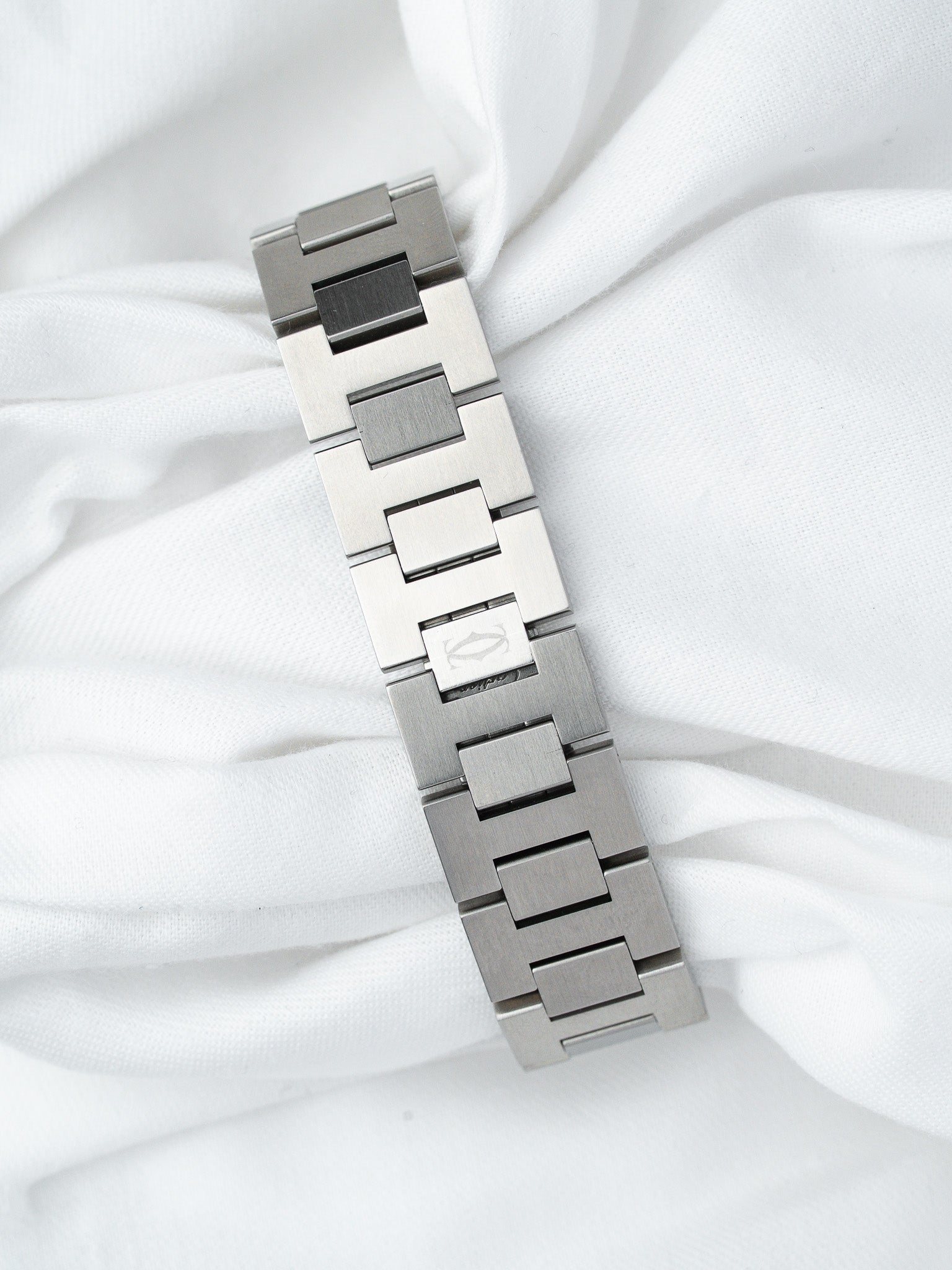 Cartier vintage watch bracelet in brushed steel with logo clasp on white fabric