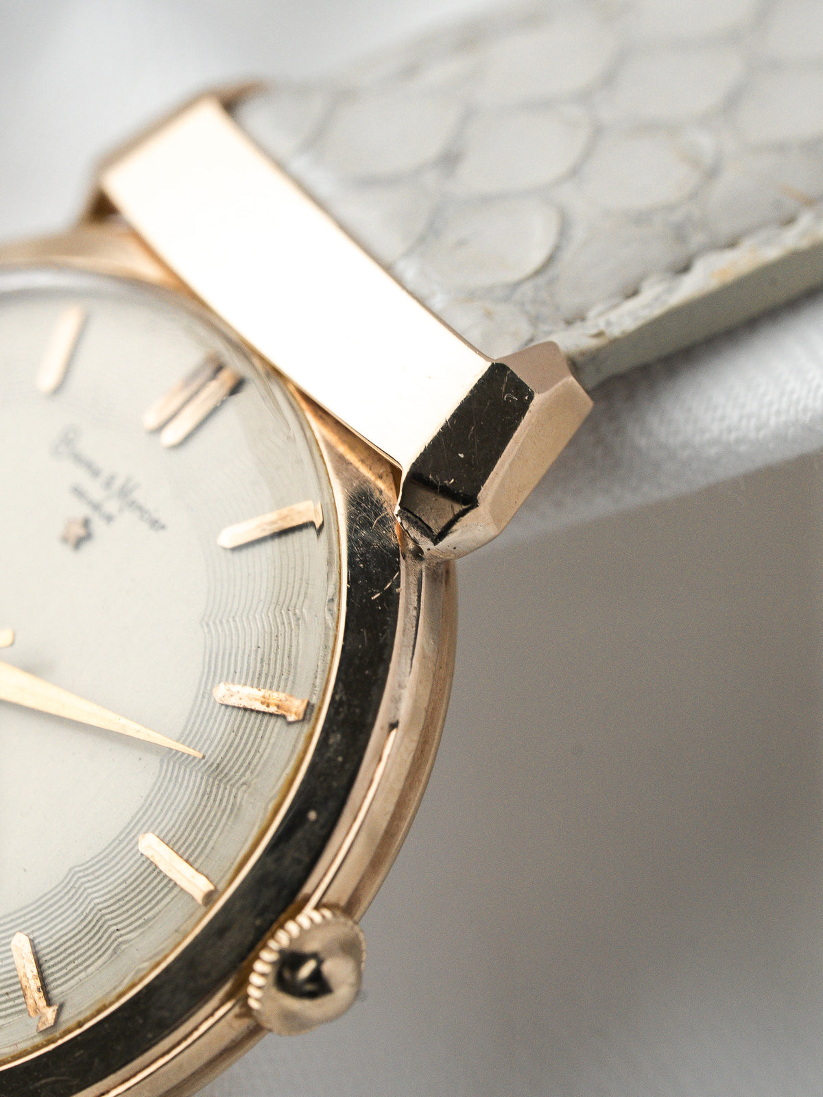 Montre Baume & Mercier vintage en or, cadran blanc et bracelet cuir gris