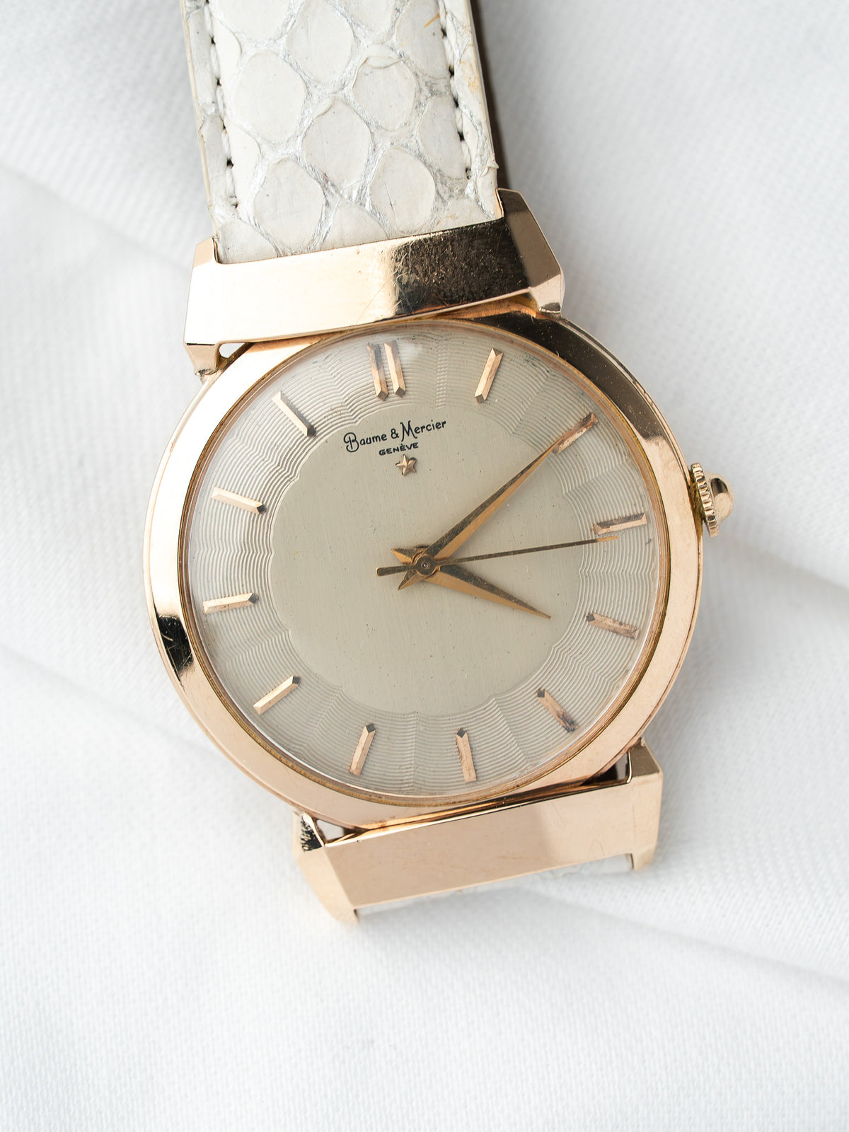 Montre Baume & Mercier vintage en or, cadran argenté et bracelet cuir blanc