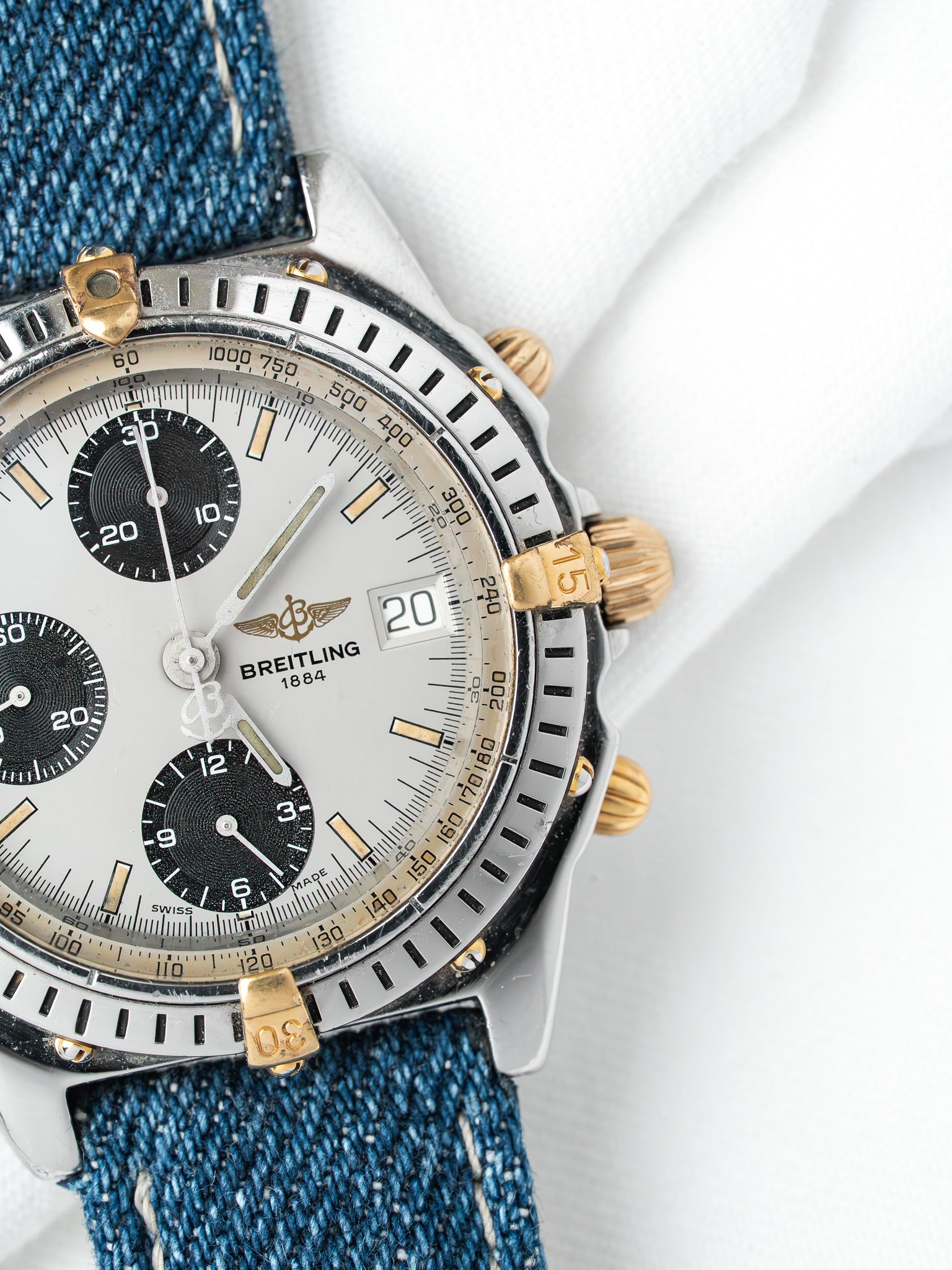 Breitling chronograph vintage with silver dial, black subdials, gold accents, denim strap