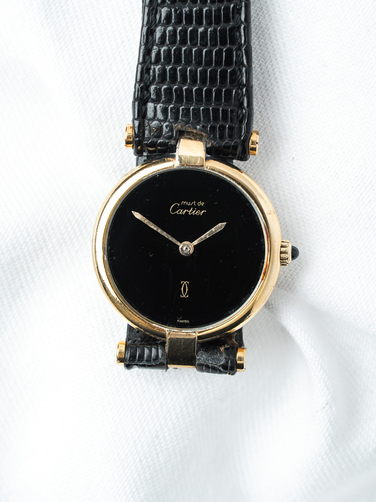 Cartier Must de Cartier vintage watch with gold case, black dial, and black alligator strap