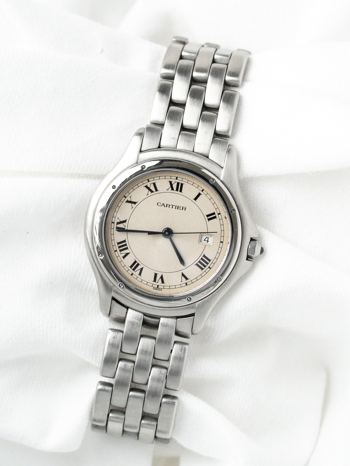 Montre Cartier vintage en acier avec cadran champagne et bracelet métallique, sur fond blanc