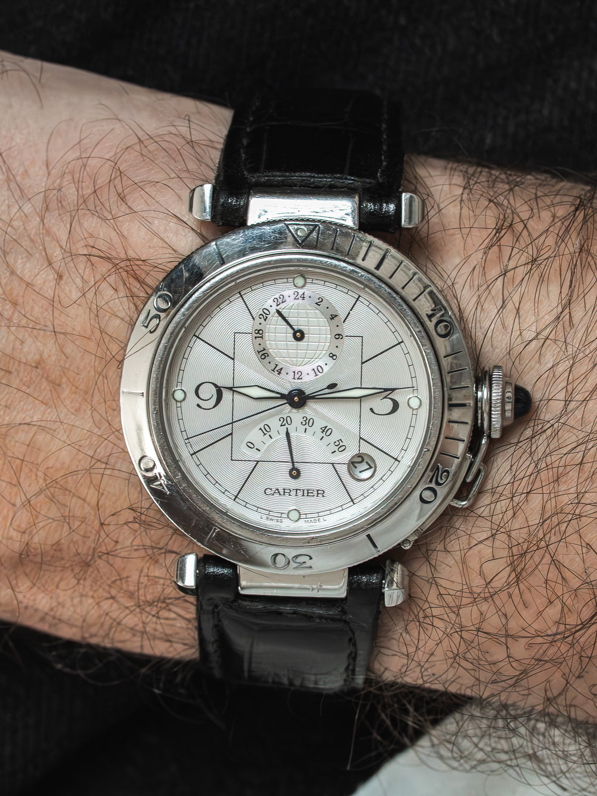 Cartier vintage watch with silver dial, black leather strap, worn on wrist
