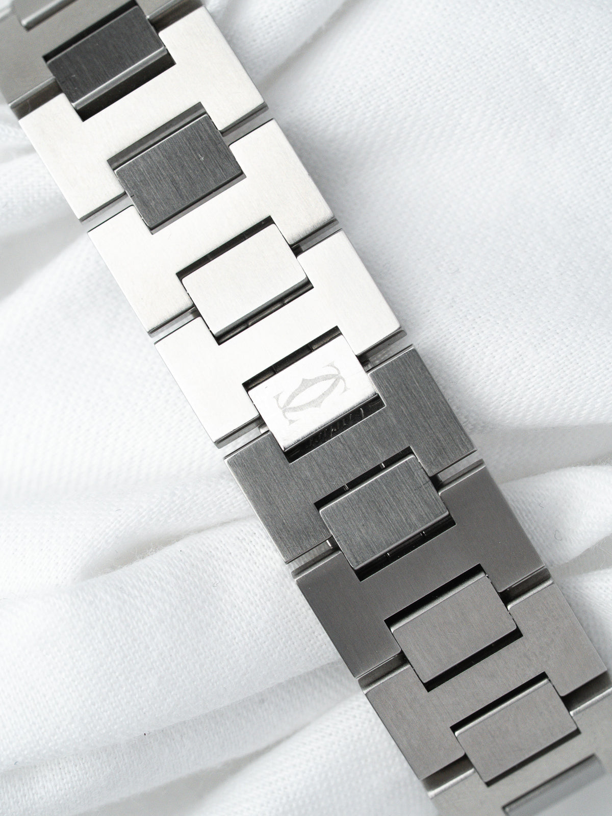 Cartier vintage watch bracelet in brushed steel with logo clasp on white fabric