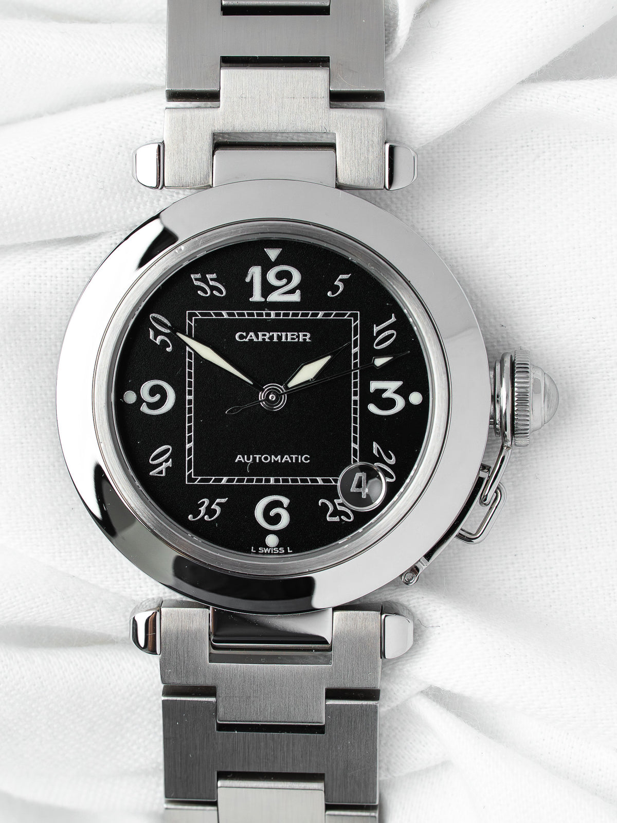 Cartier Pasha automatic watch with black dial, steel case and bracelet on white fabric