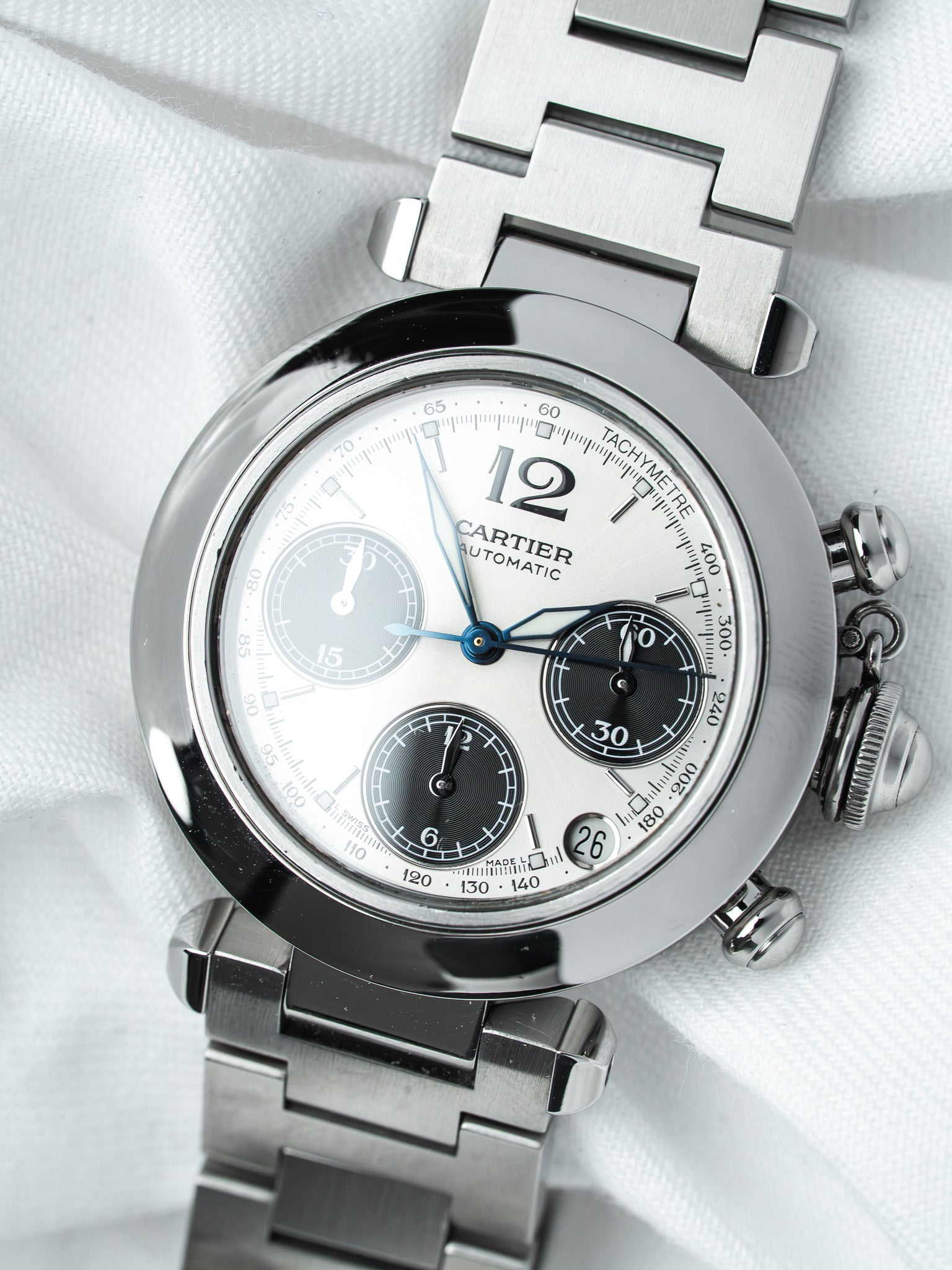 Cartier chronograph watch with white dial, steel bracelet, and tachymeter bezel