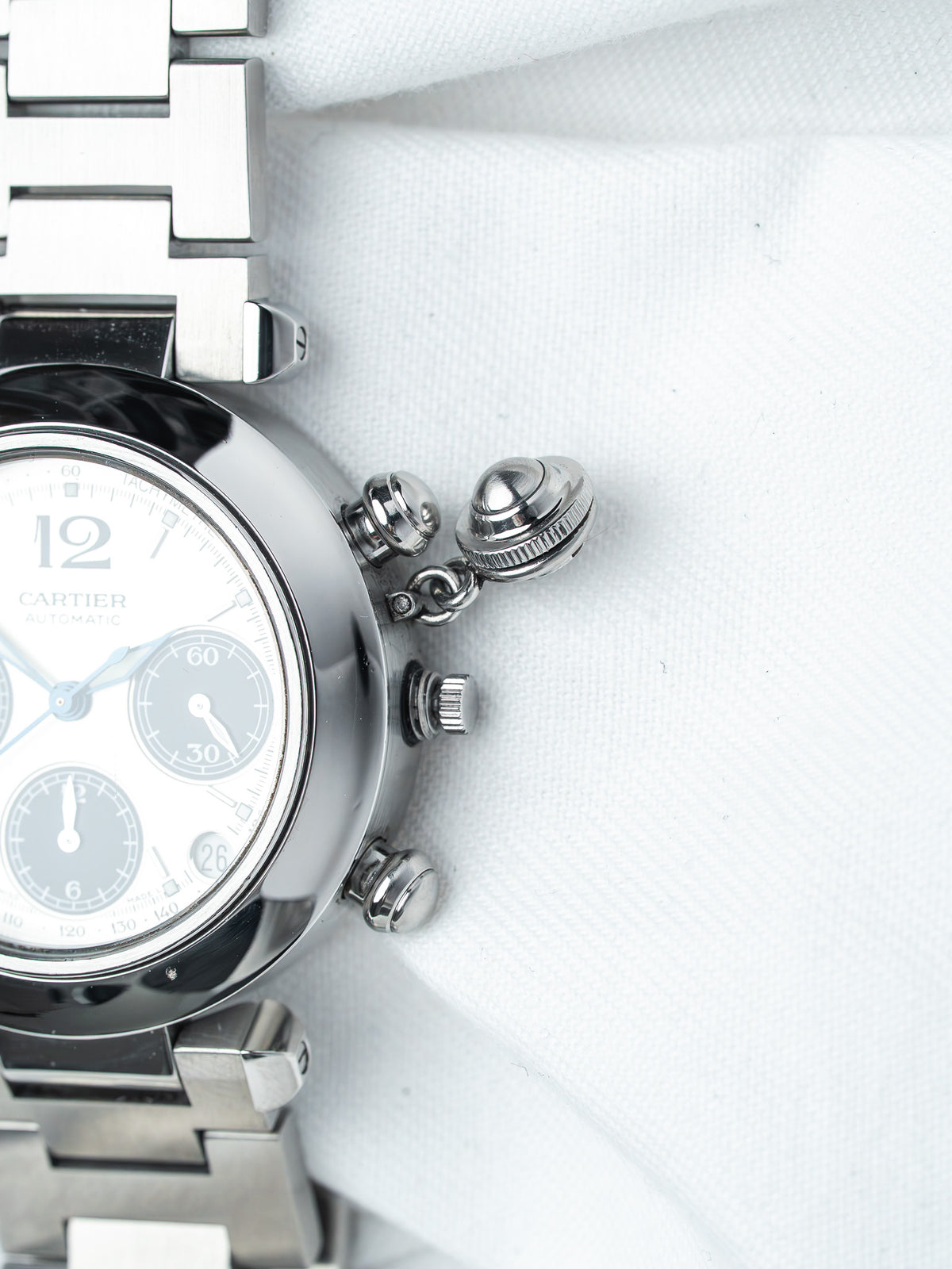 Cartier chronograph watch with silver dial, steel case and bracelet, on white fabric